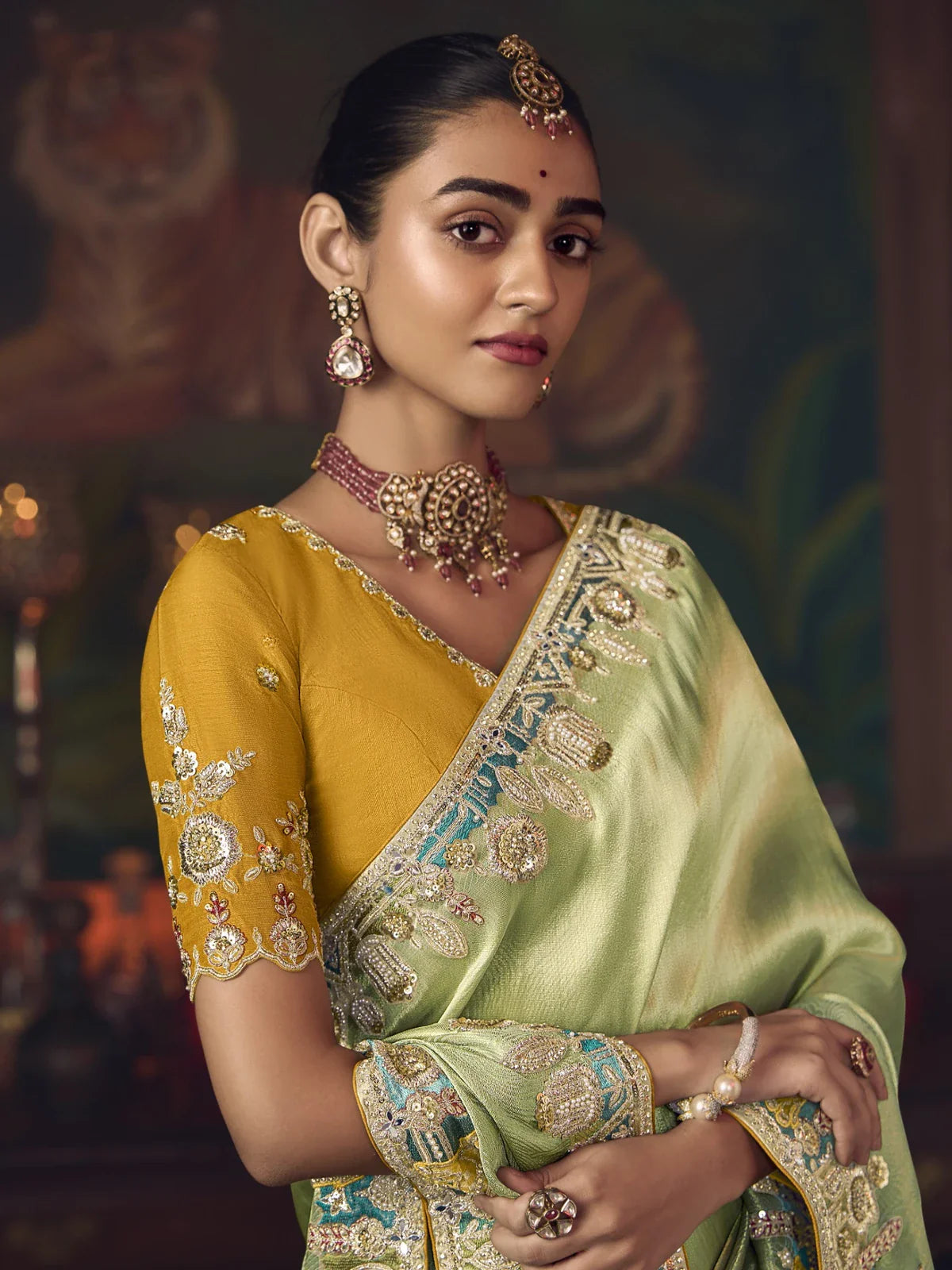 Tarani silk saree close-up showing blouse embroidery and neckline detailing in green and mustard tones