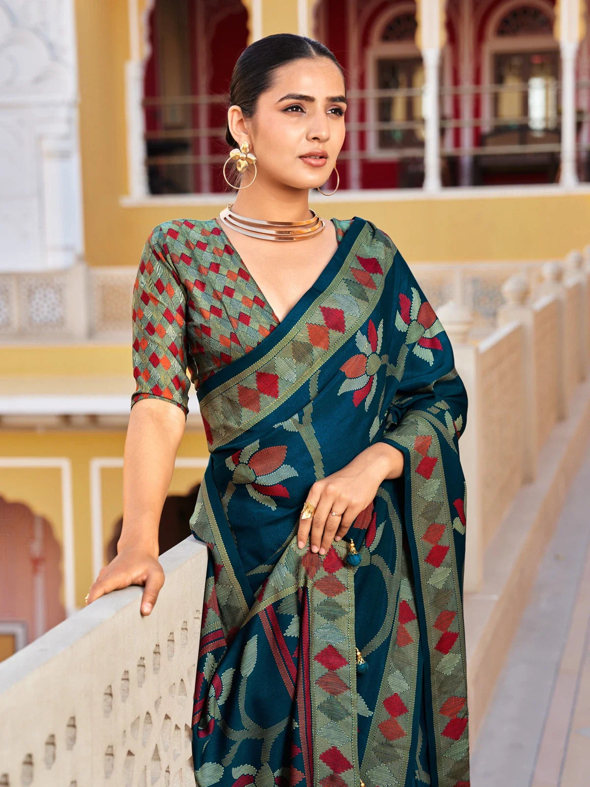 Tarani upper body view of green silk saree with red floral pallu and blouse in festive weave