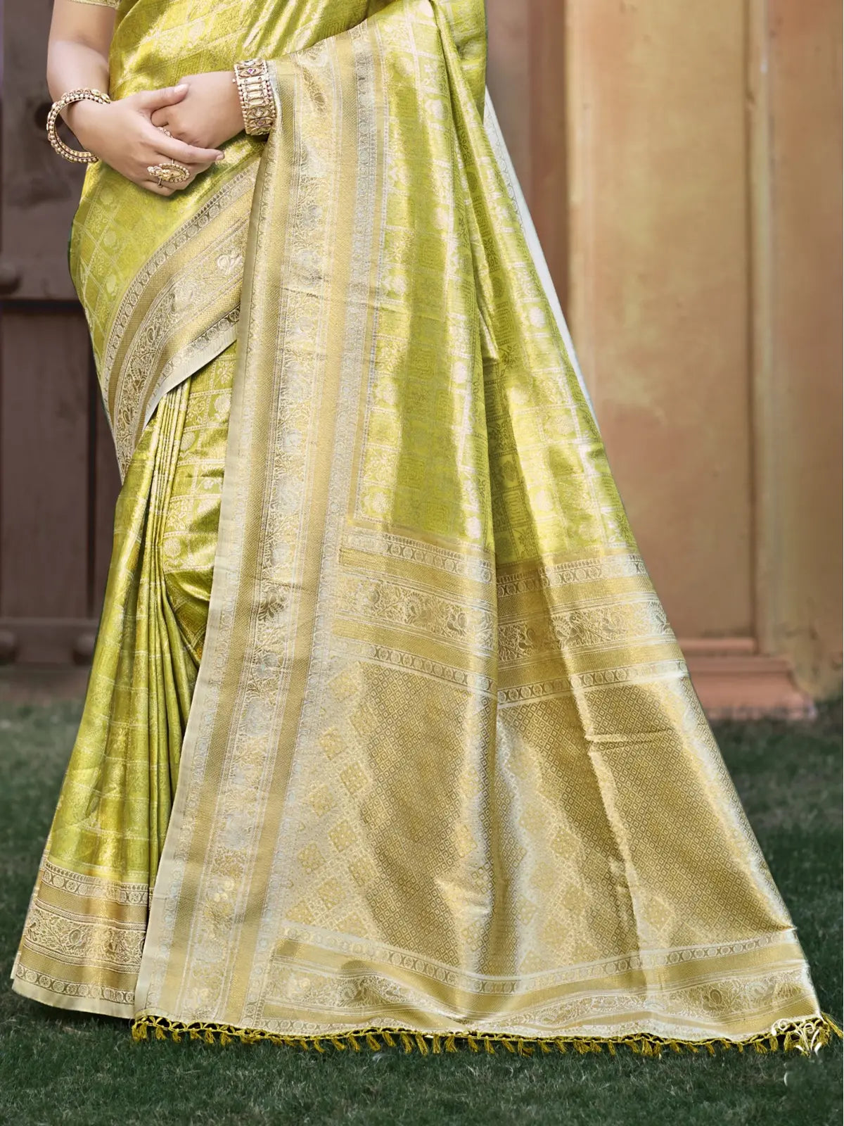 Closeup of Tarani light green Kanjivaram silk saree showing detailed zari border and soft fabric texture