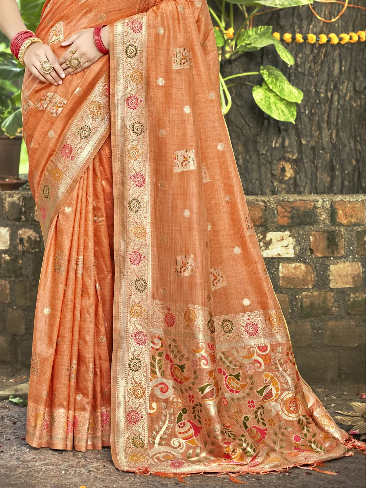 Tarani Kimiyavitika orange silk saree pallu close view with floral zari weaving and contrast border detailing