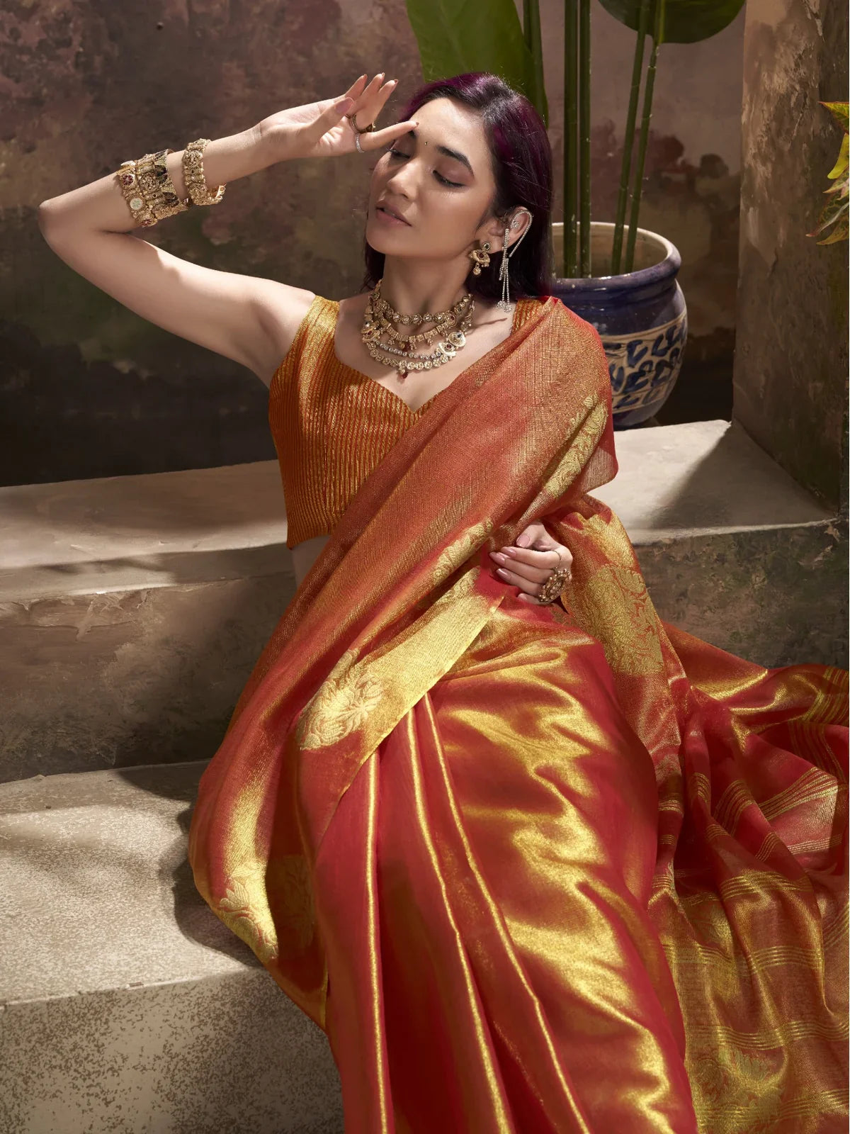 Tarani traditional orange tissue silk saree upper body closeup with jewelry styling