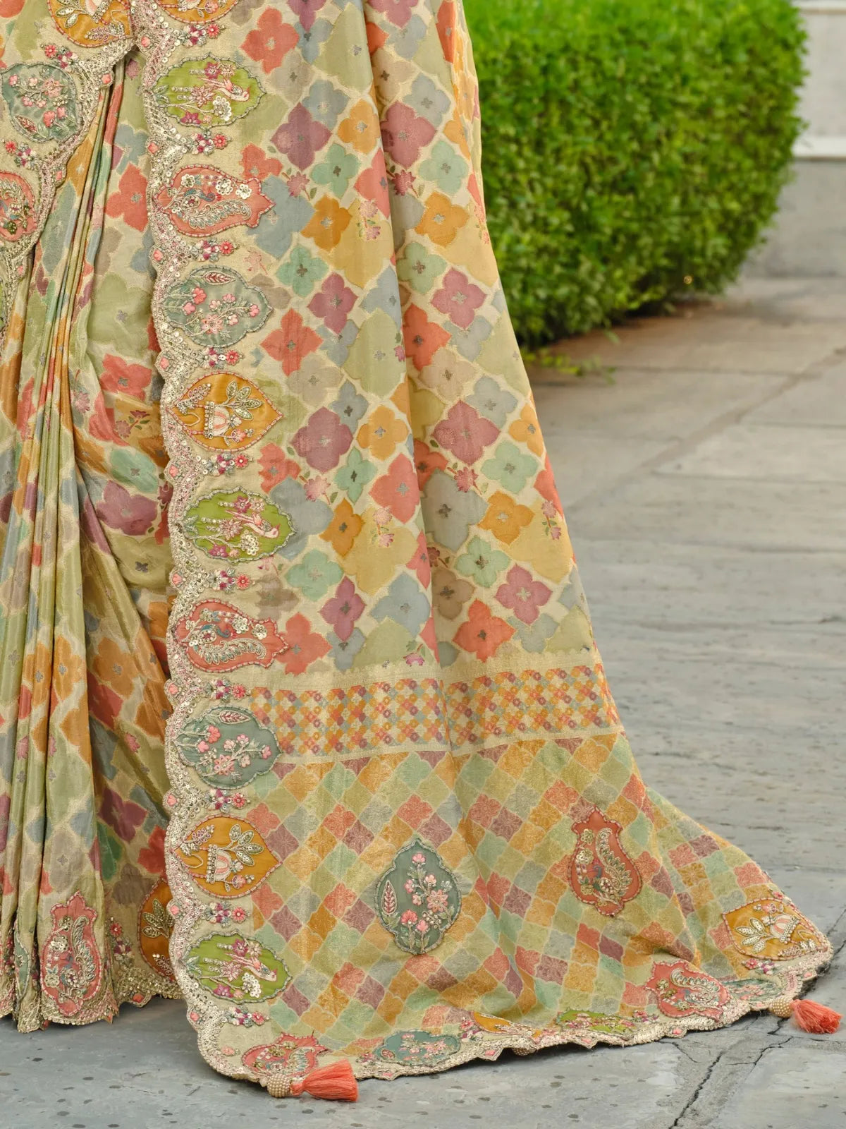 Tarani pastel saree pallu close-up showing intricate border embroidery and soft festive colors