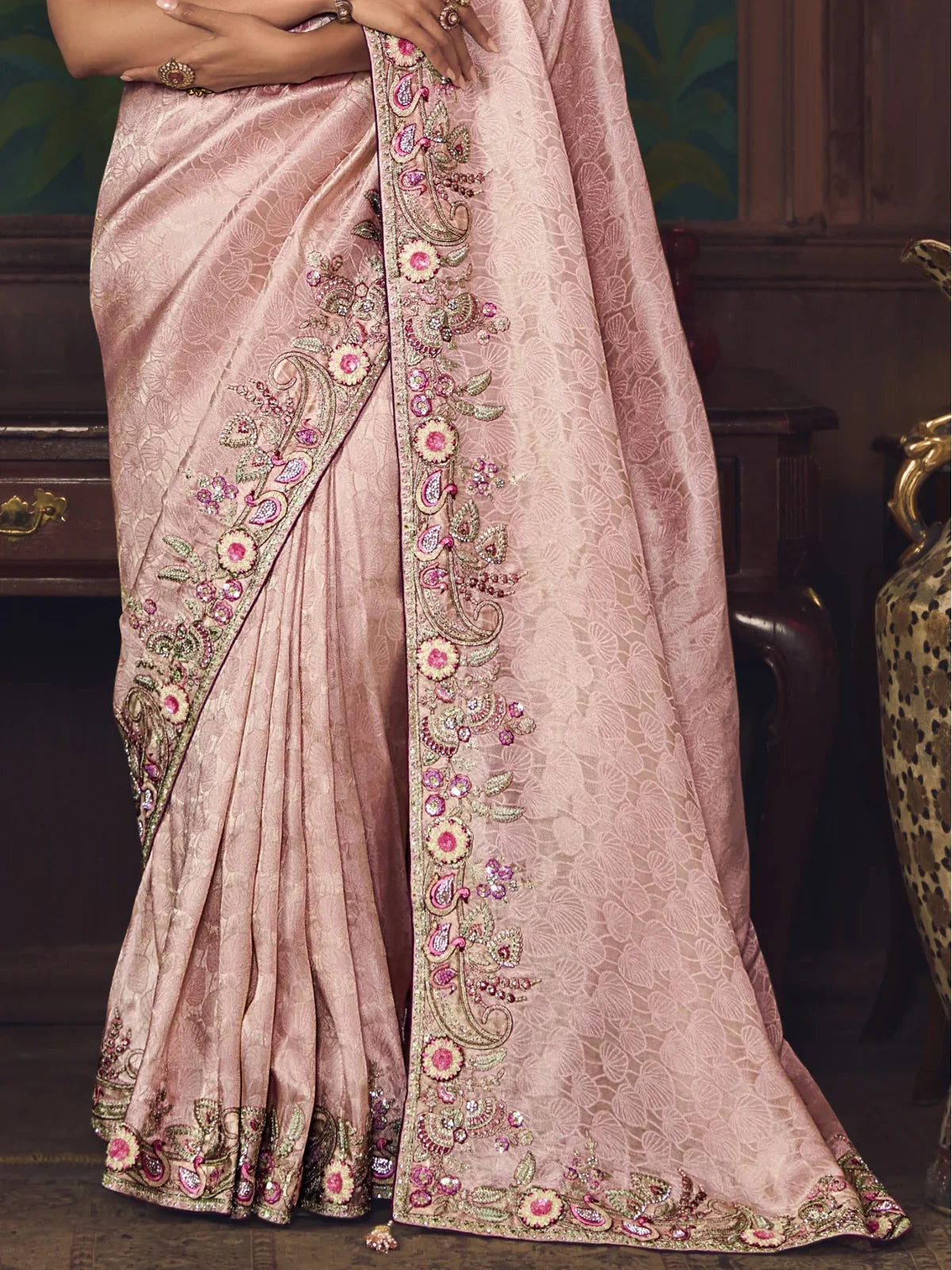 Tarani close pallu view showcasing pink floral embroidery and shimmering border of partywear silk saree