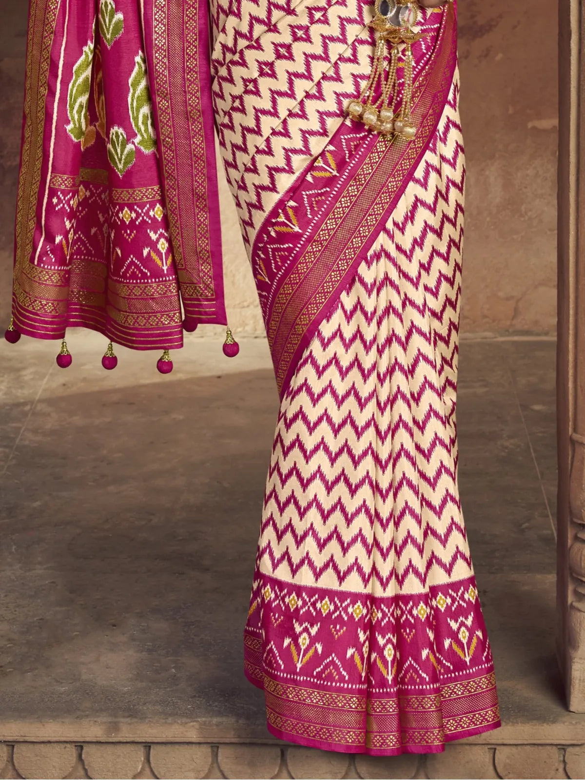 Tarani pink patola saree pallu view with embroidered border and tassels