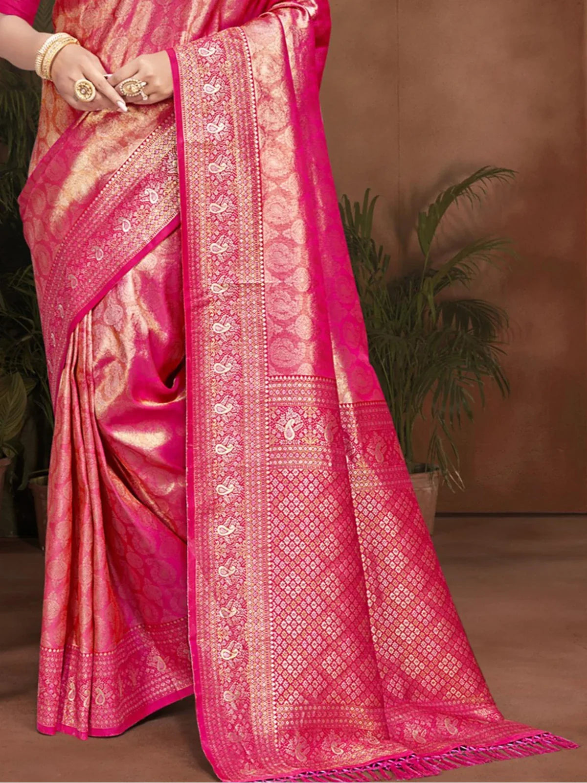 Tarani kanjivaram silk saree pallu view with detailed golden weaving pattern and pink tone