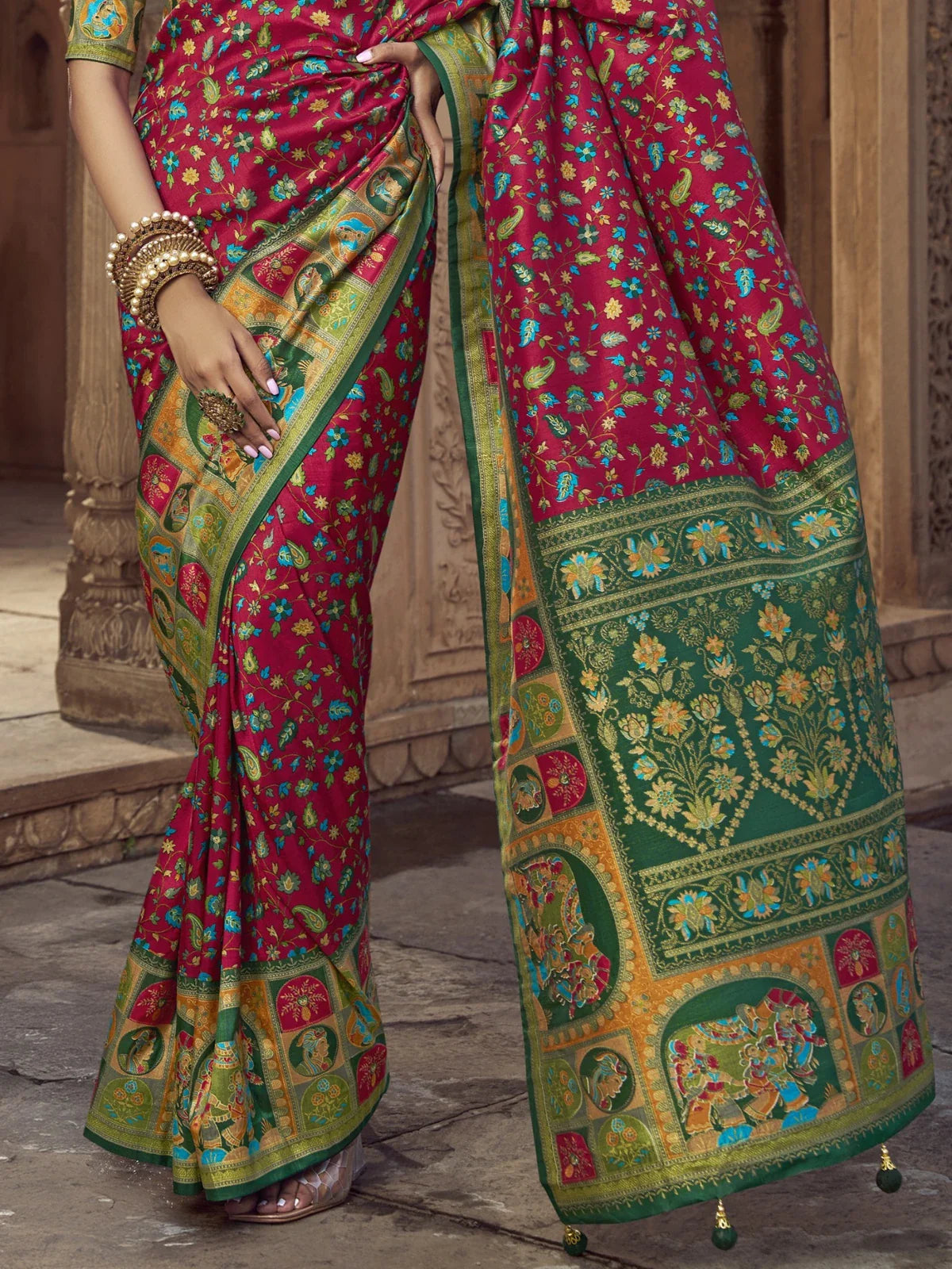 Tarani designer red silk saree close-up showcasing intricate green golden border work