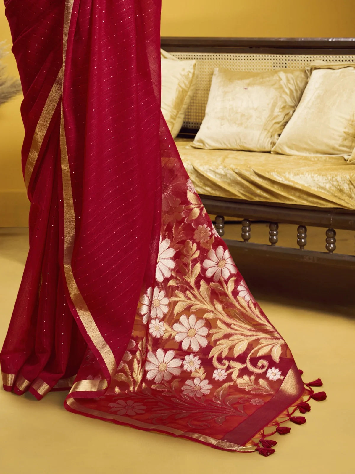 Tarani pallu view of red silk saree with golden floral motifs and tassels