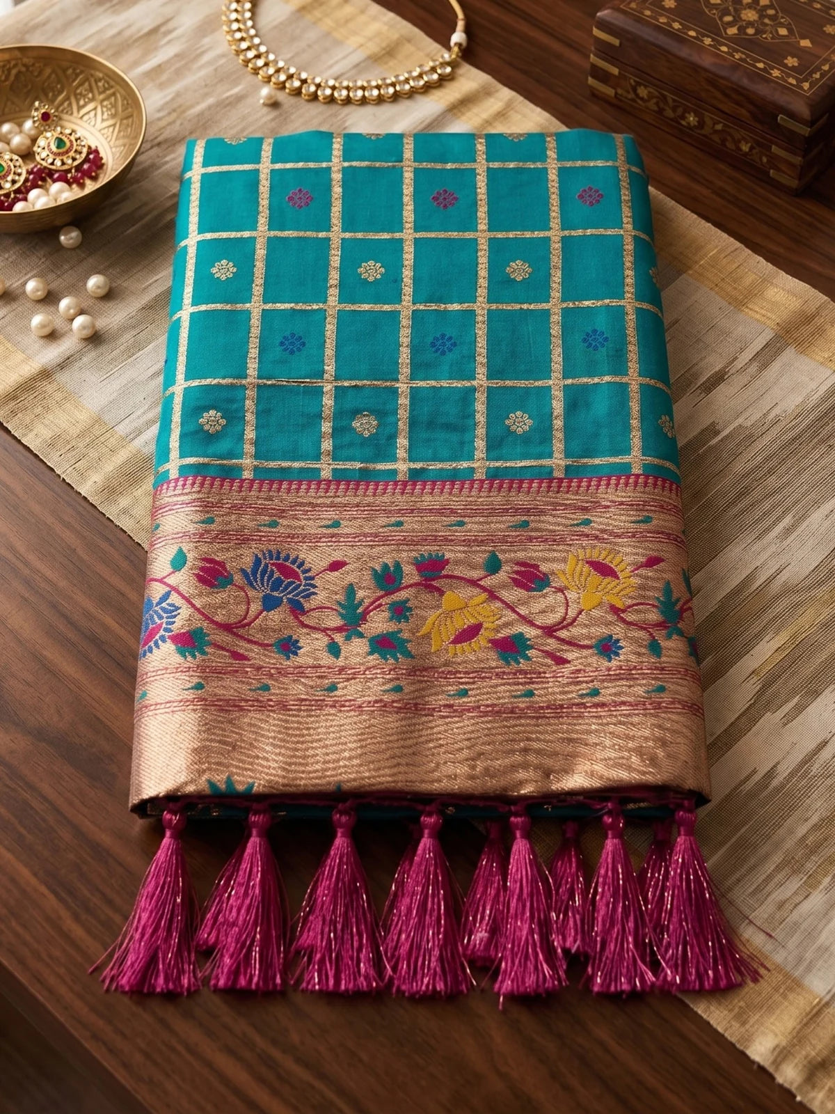 Tarani Banarasi silk teal saree fabric closeup with zari checks floral border and tassels