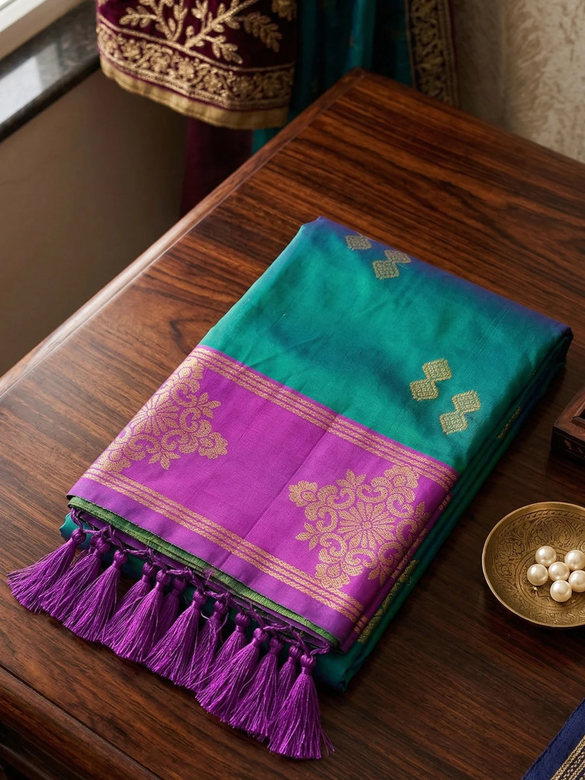 Tarani teal soft silk saree folded fabric closeup with zari border and tassel finish