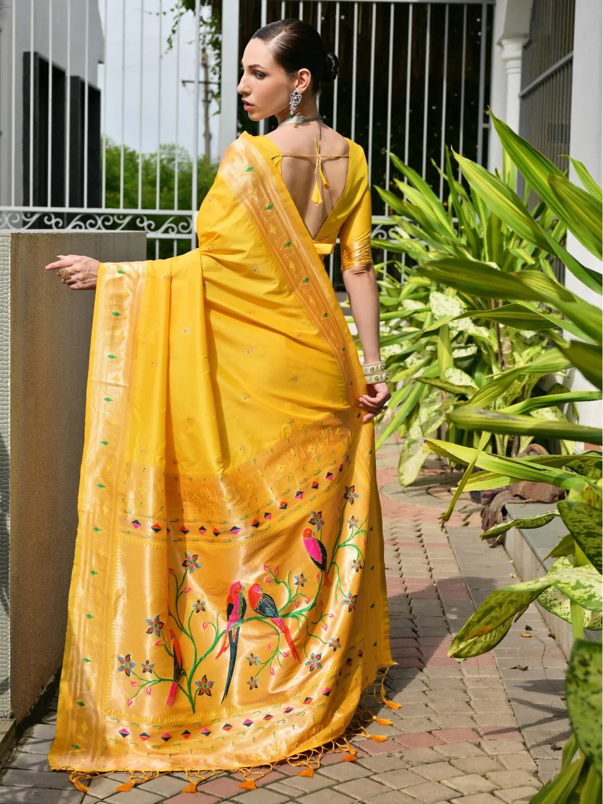 Tarani yellow banarasi silk saree back pose showing pallu fall and blouse tie-back