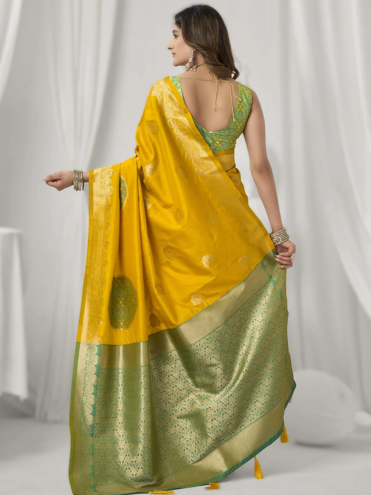 Back view of Tarani yellow silk saree with contrast green blouse and tassels