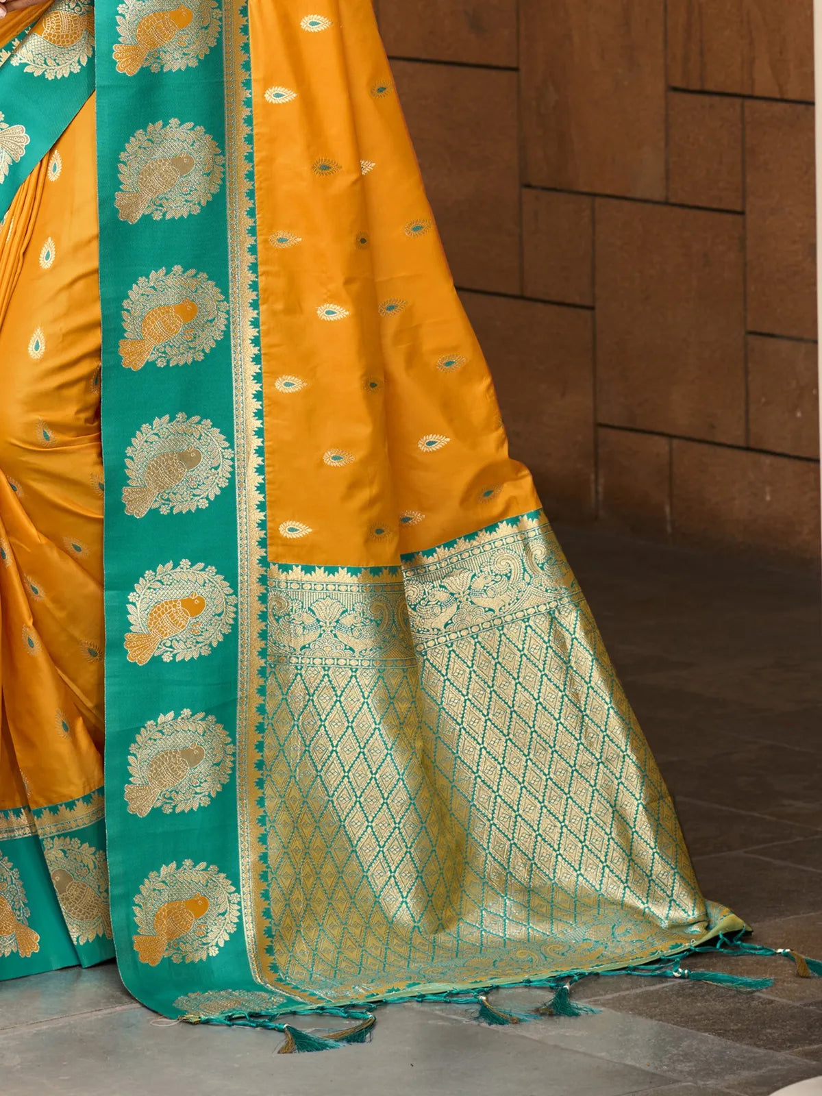 Tarani detailed pallu view of yellow silk saree with green zari border and fish motifs for party and pooja occasions