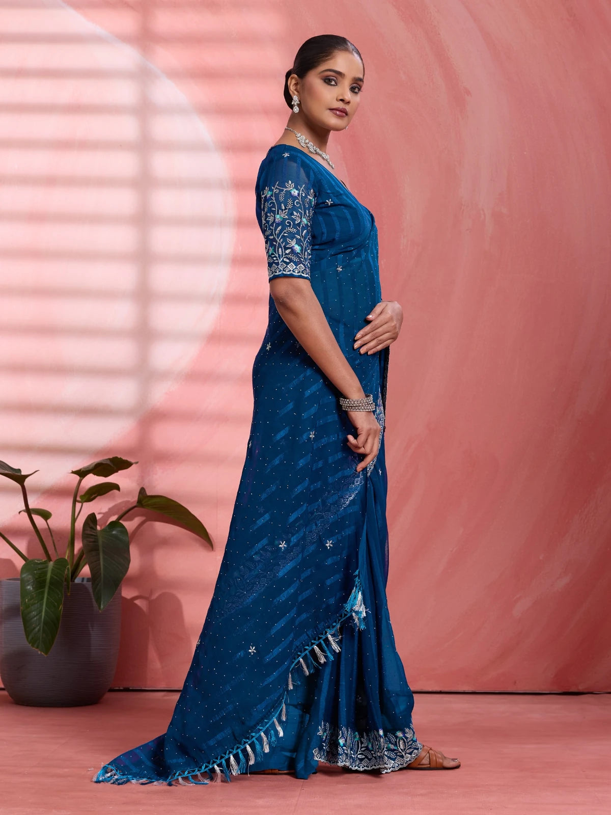 Tarani navy blue solo chiffon saree side view showcasing graceful drape and embroidered sleeve detailing