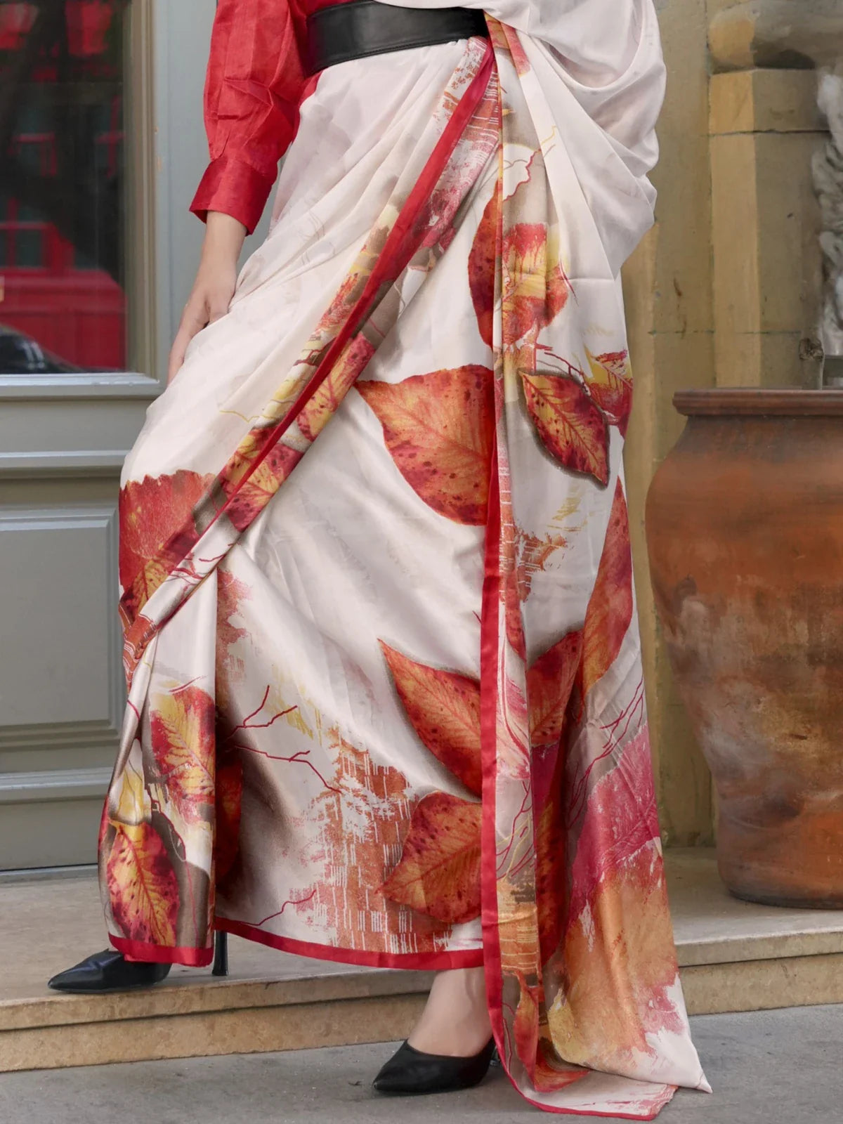 Close-up of Tarani Spanish satin saree showing fall leaf pattern and red border – closeup view