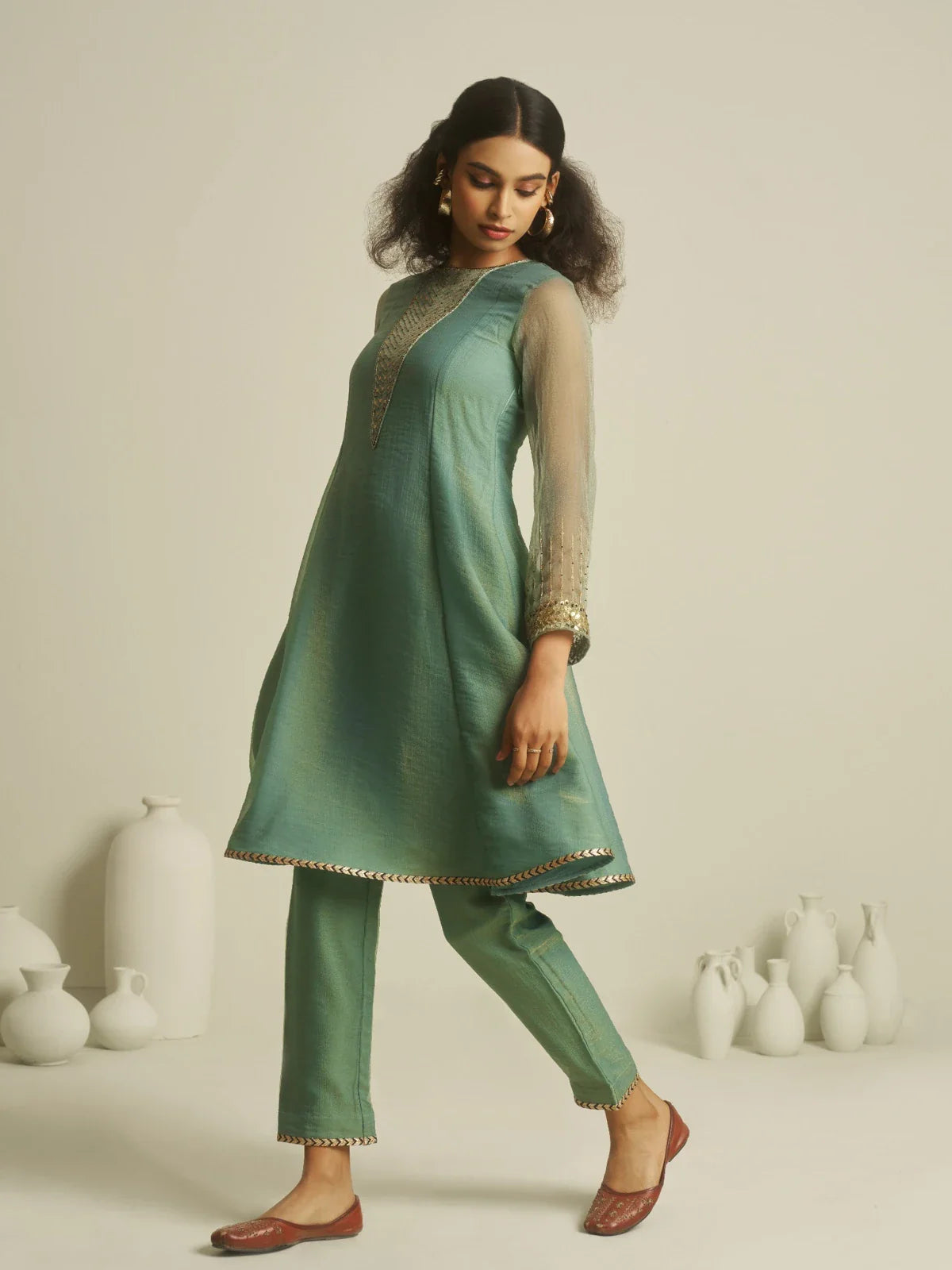 Tarani premium tissue dress side pose highlighting flare and fall of the festive outfit