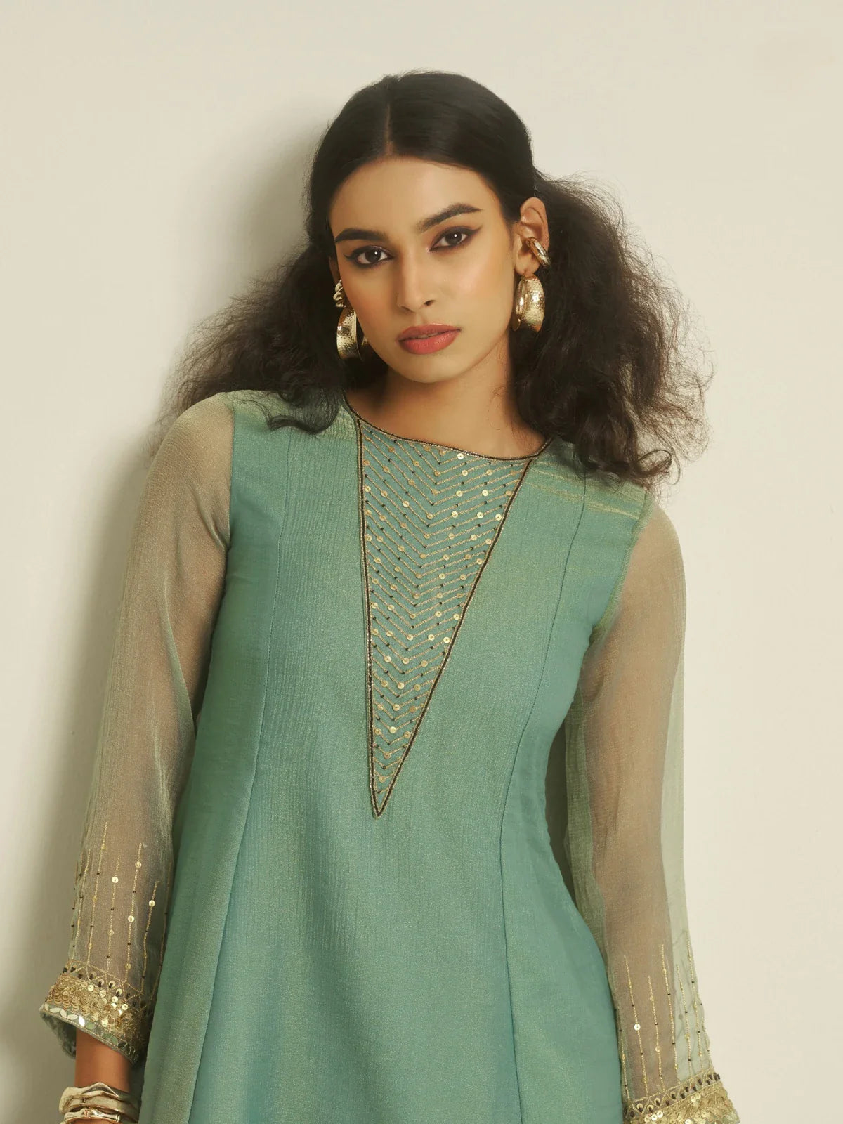 Tarani green tissue party dress upper body close-up showing sheer sleeves and neck work