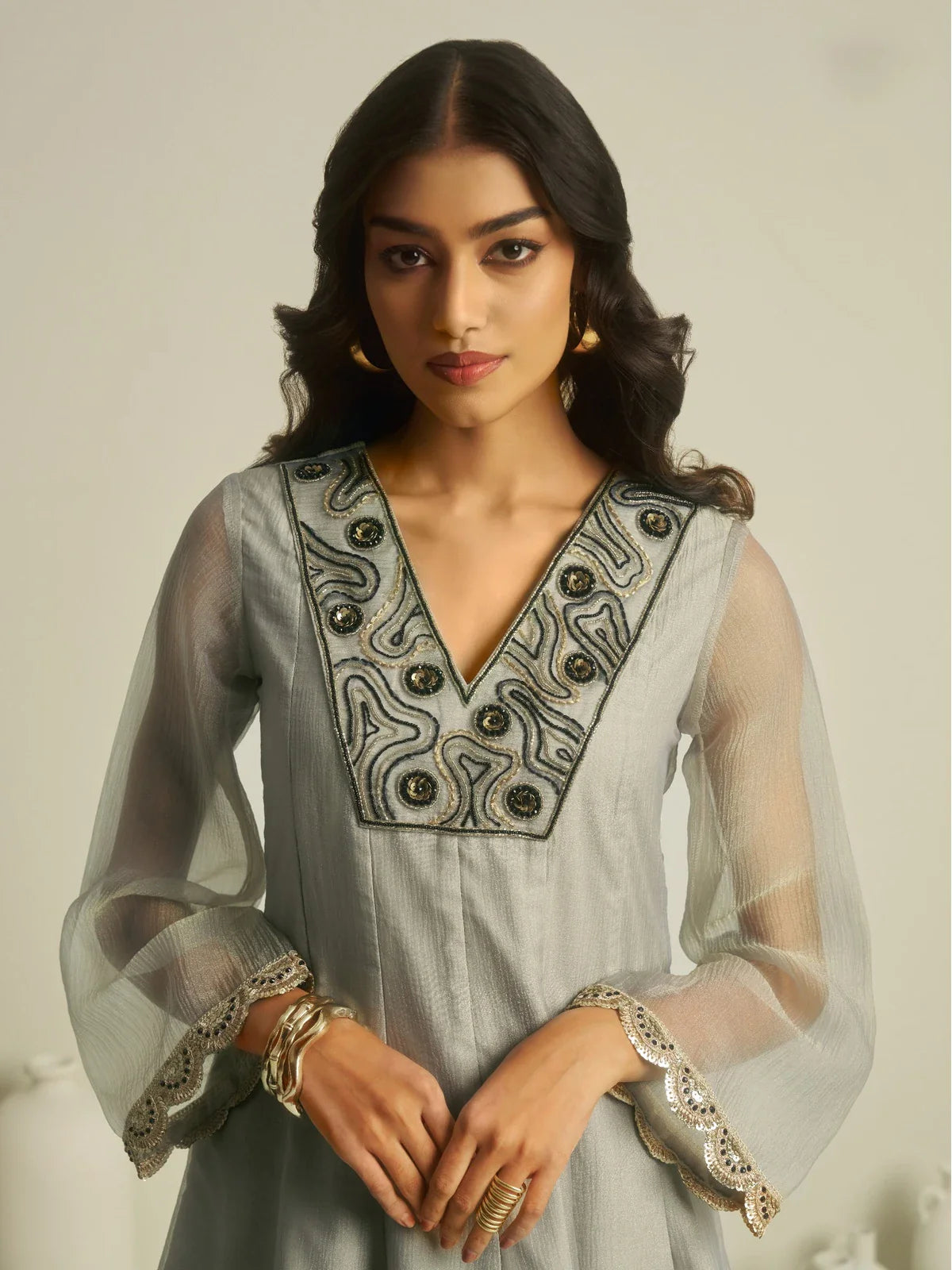 Tarani closeup view of grey tissue dress showing handworked neckline and sheer sleeves