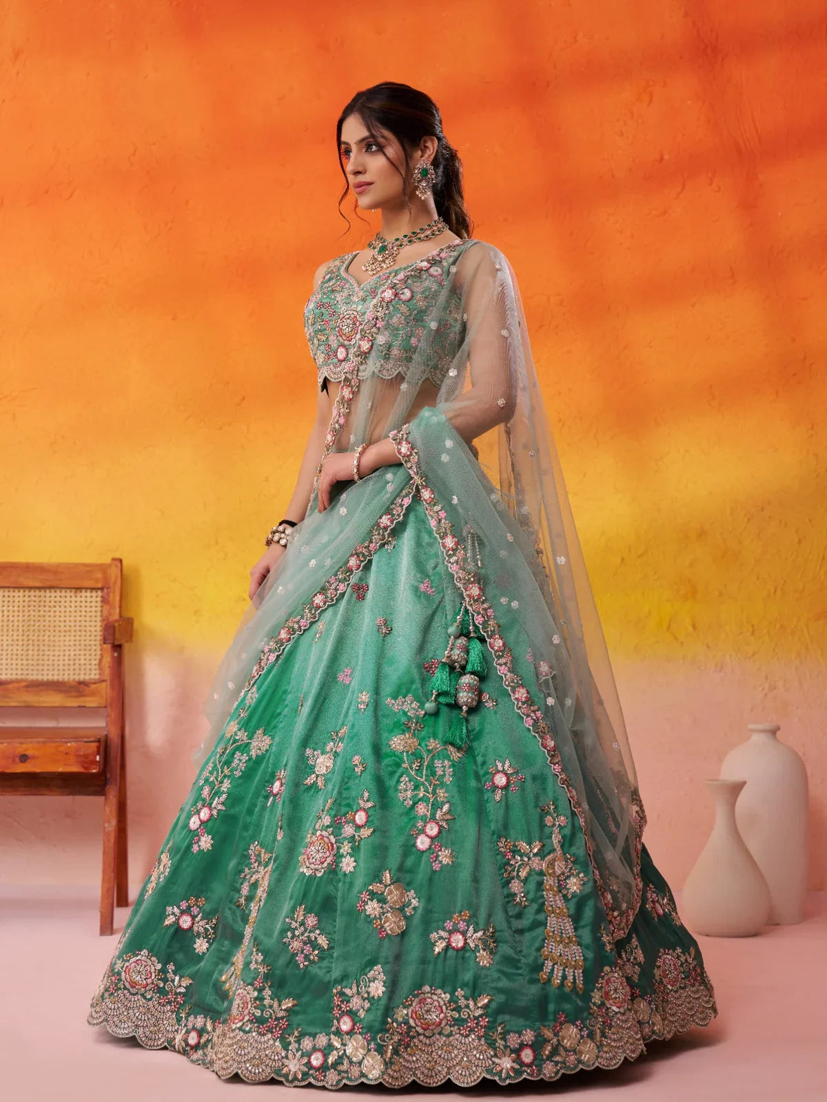 Tarani side pose of green tissue lehenga showing flare and floral embroidery