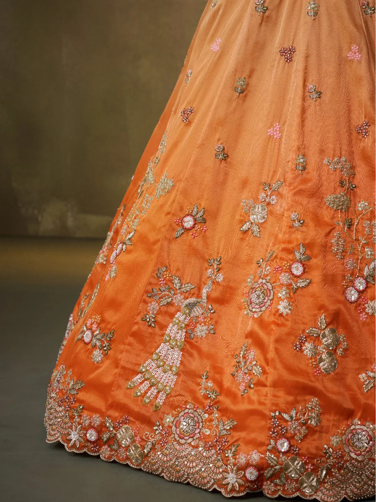 Tarani closeup embroidery detailing on orange lehenga with peacock motif