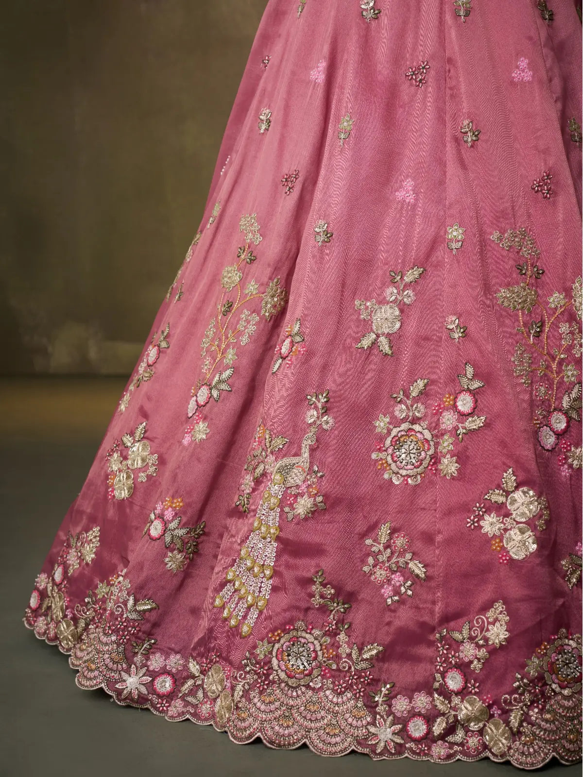 Tarani closeup of fabric embroidery and peacock design on pink tissue lehenga
