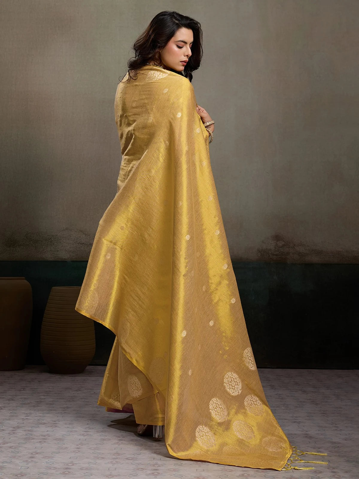 Tarani Samaira golden tissue silk saree back view with elegant flowing pallu and woven motifs