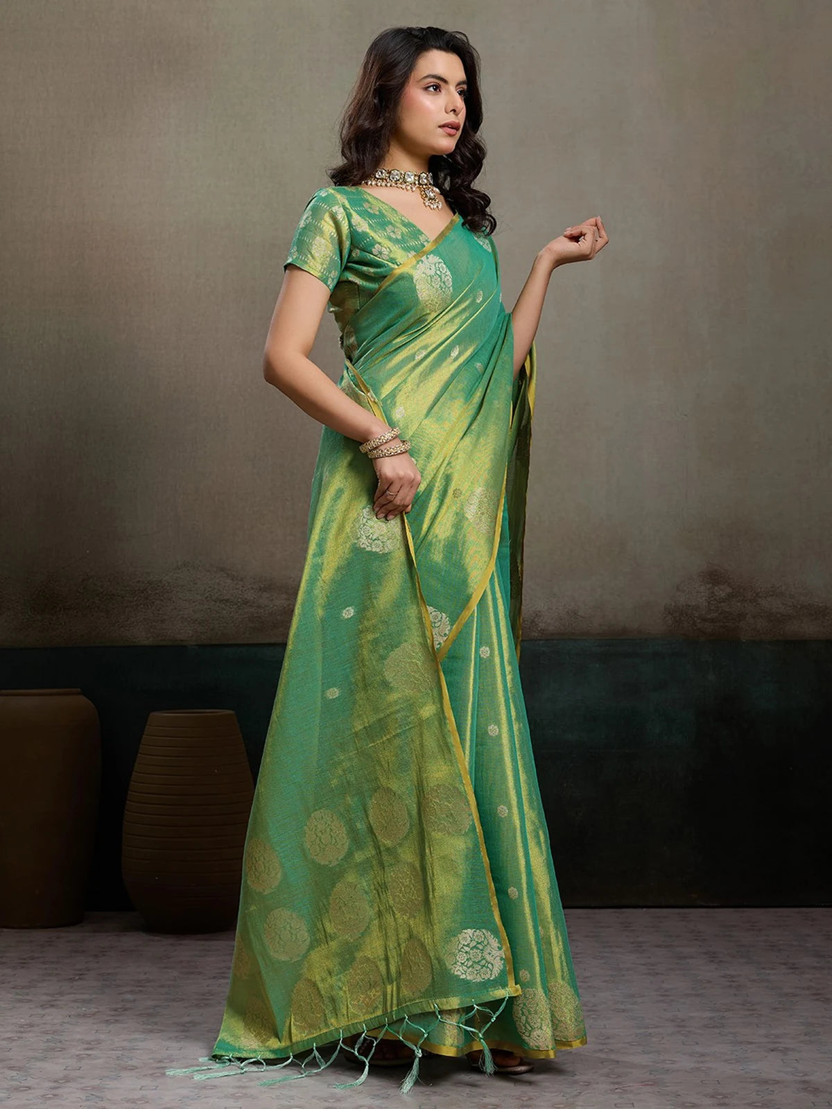 Tarani green tissue silk saree side view with graceful pallu and festive styling