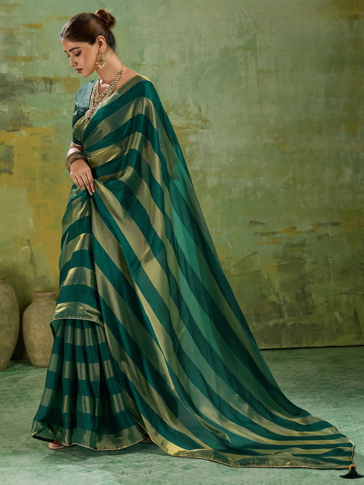 Tarani green velvet satin saree side view showing elegant drape and striped border