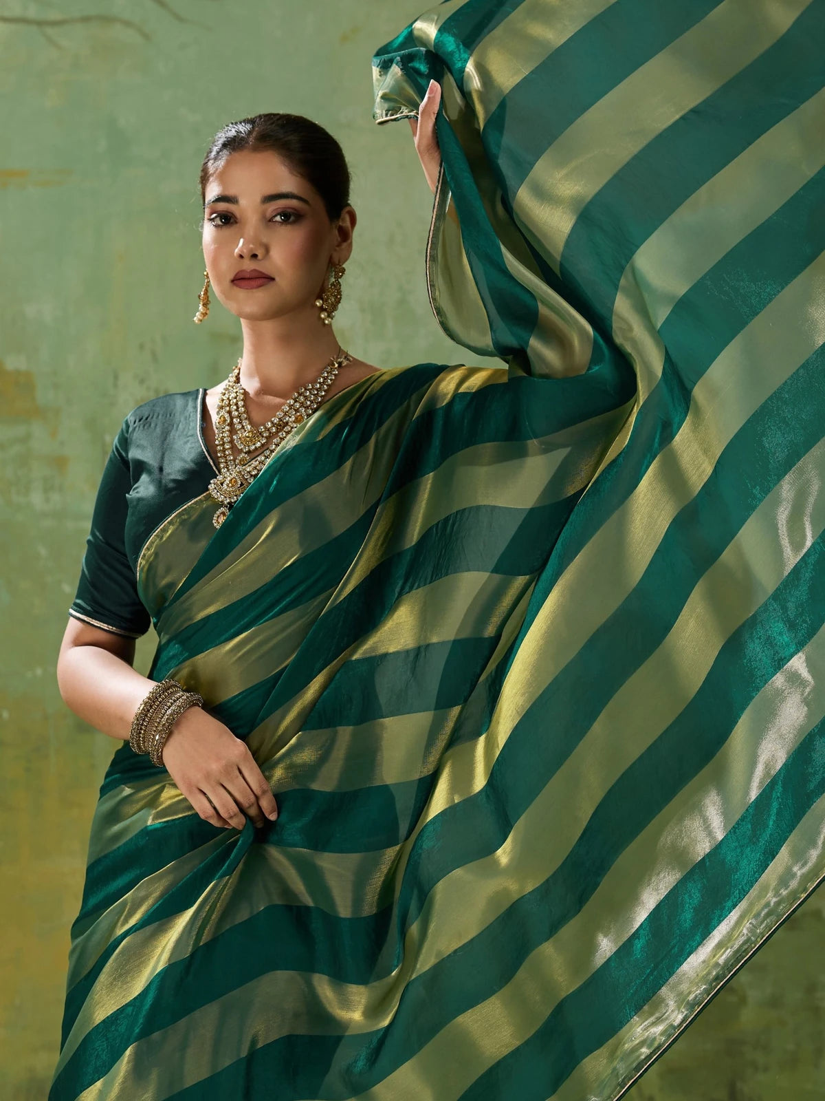 Tarani green velvet satin saree upper body view highlighting metallic gold border and blouse
