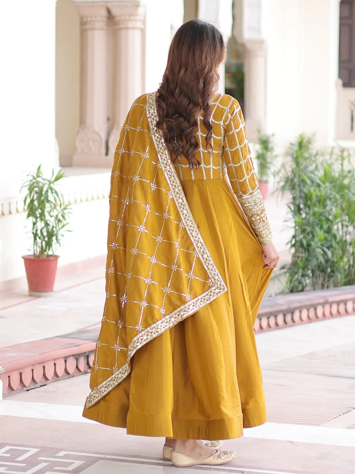 Back view of Tarani mustard embroidered vichitra gown with dupatta drape
