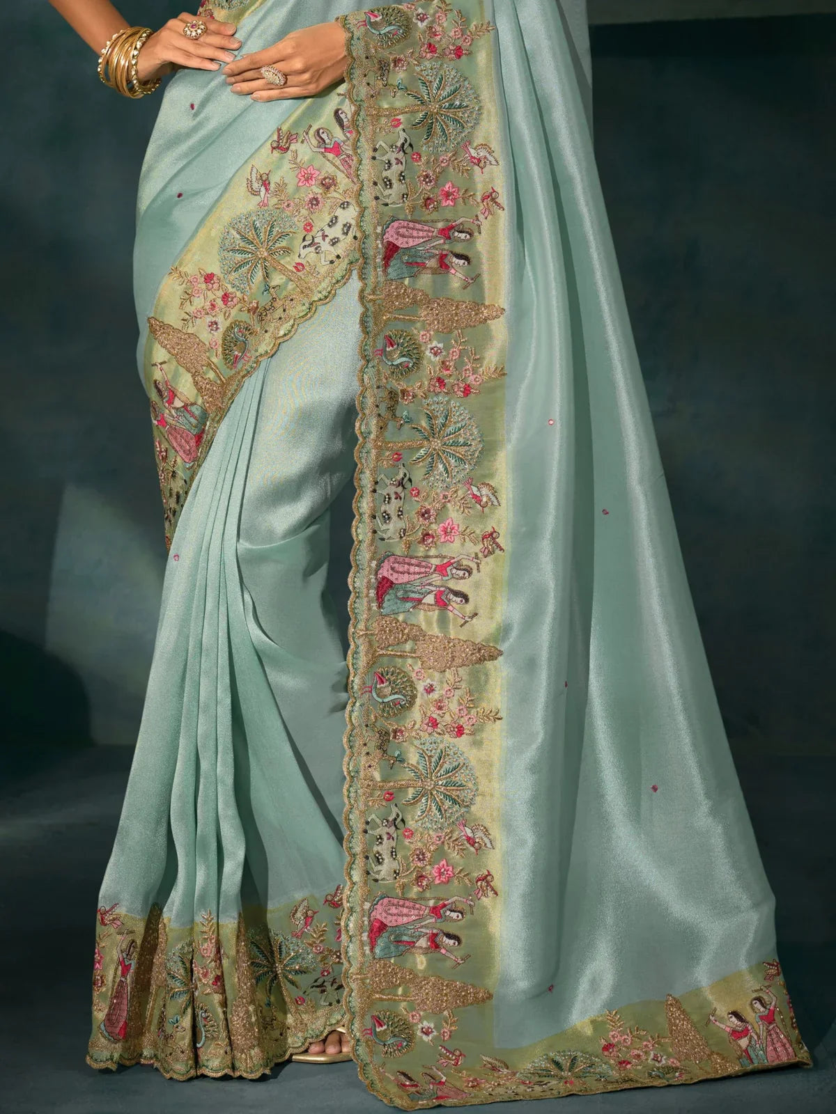 Tarani green banarasi saree pallu closeup showing detailed embroidery and festive design