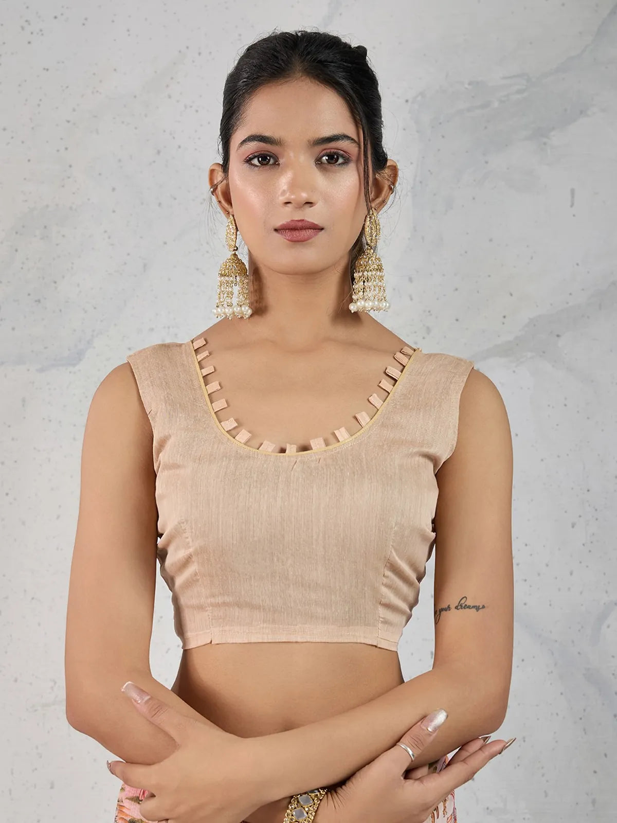 Tarani model in sleeveless blouse wearing chanderi pink saree showing upper body and accessories