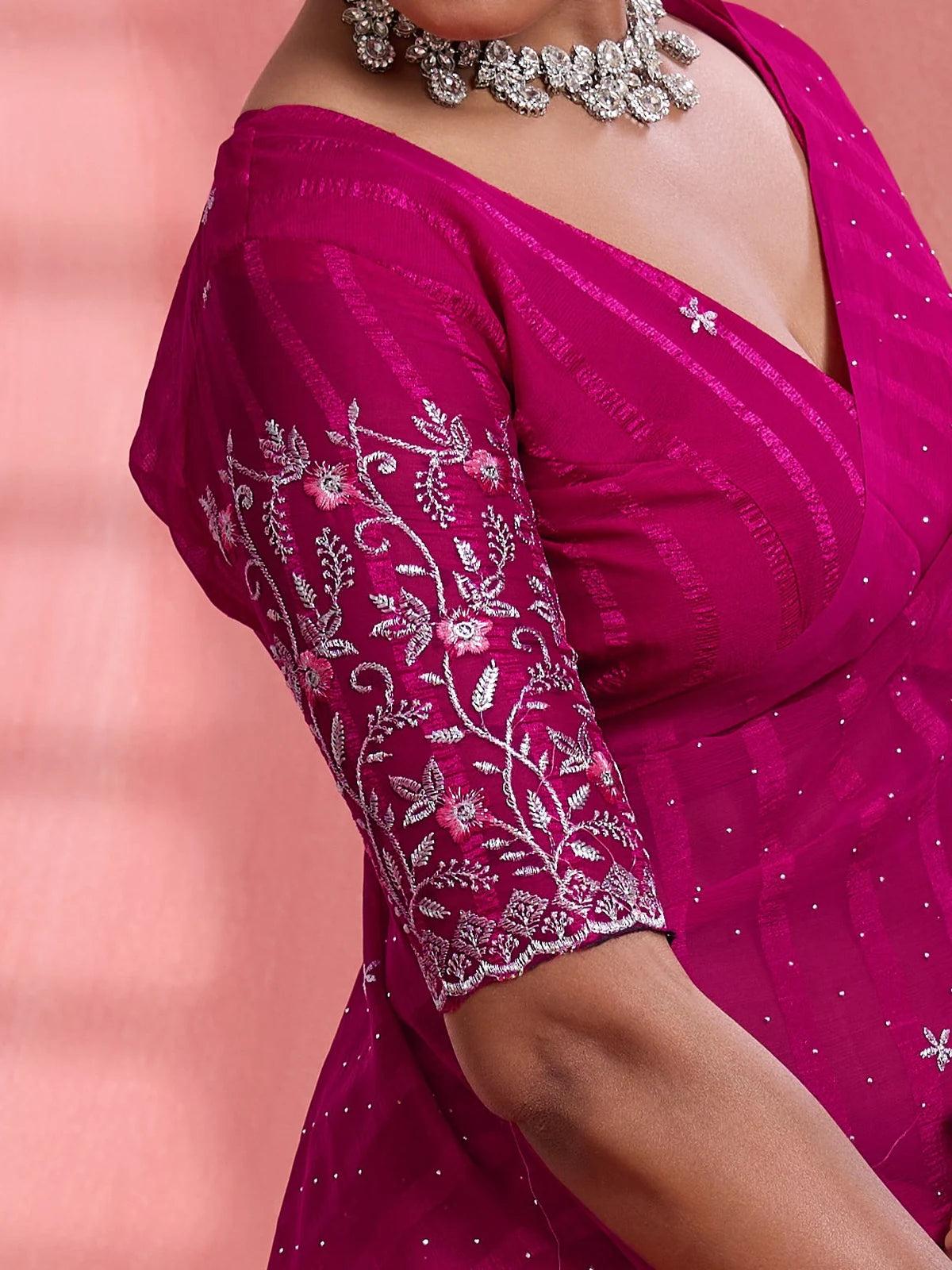 Tarani magenta saree blouse closeup with floral embroidery sleeve detailing