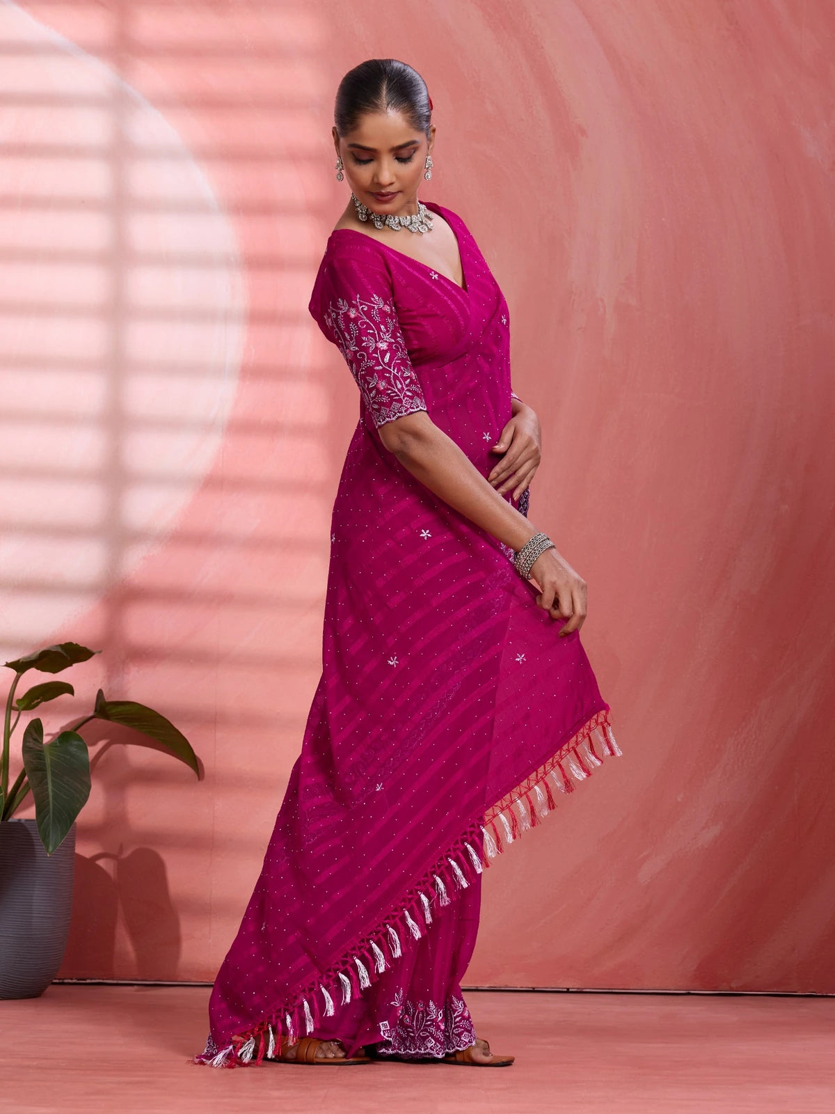 Tarani festive magenta chiffon saree side pose with elegant drape and tassel pallu