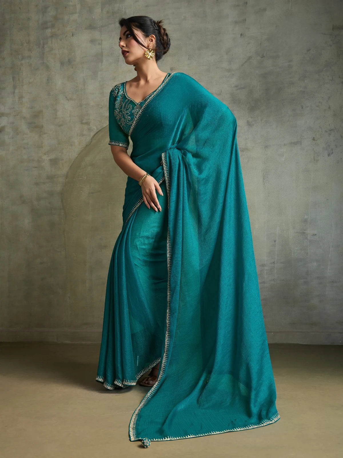 Tarani teal chiffon saree side pose showcasing flowing pallu and premium zarkan detailing