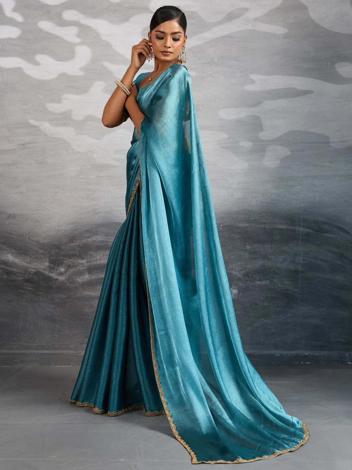 Tarani teal chiffon saree side view showing fluid drape and scalloped lace edging
