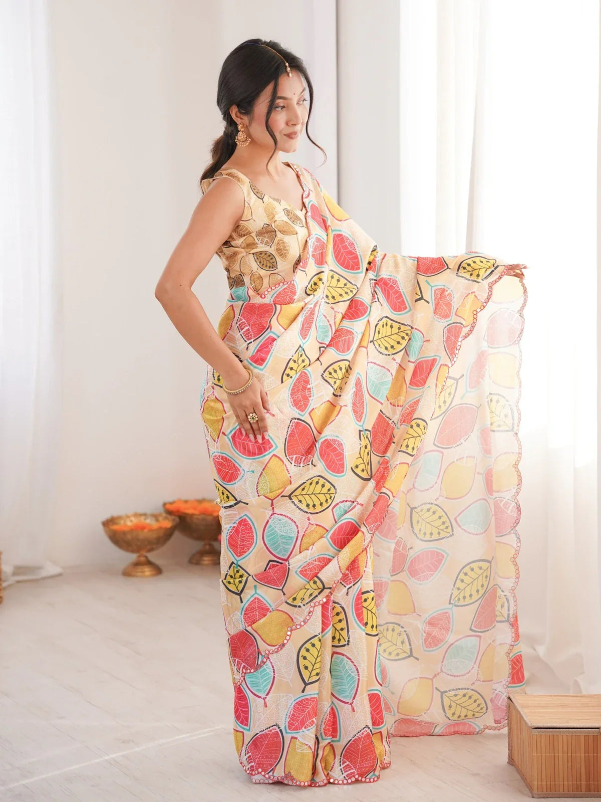 Side view of Hema wearing beige Tarani Chinnon saree styled with vibrant leaf prints and flowy drape