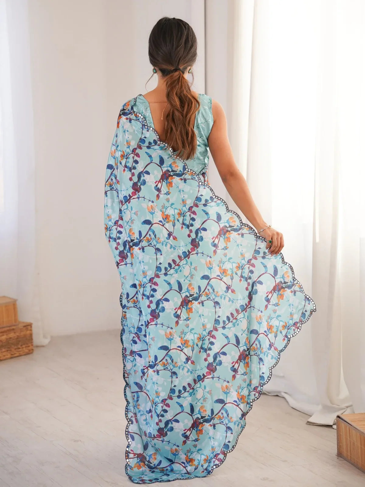 Tarani graceful back view of the blue chinnon saree with soft drape and elegant blouse design