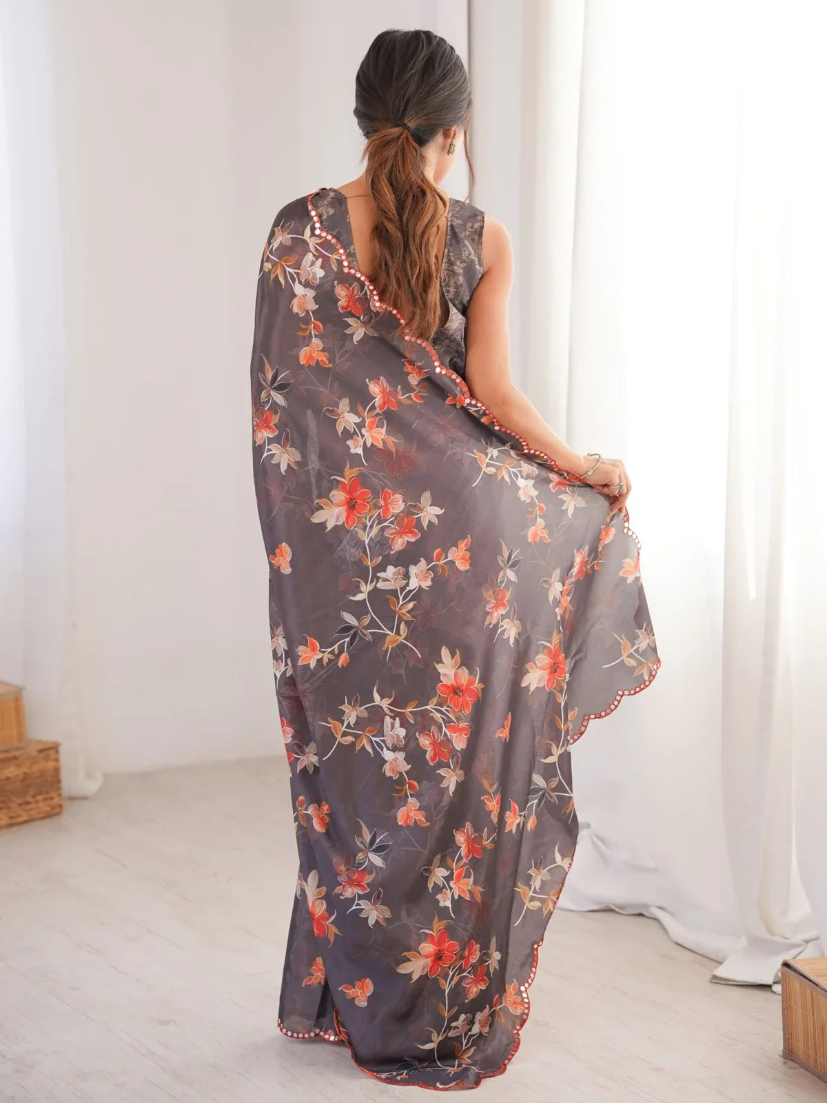 Tarani back view of grey printed chinnon saree with red flowers and mirror border