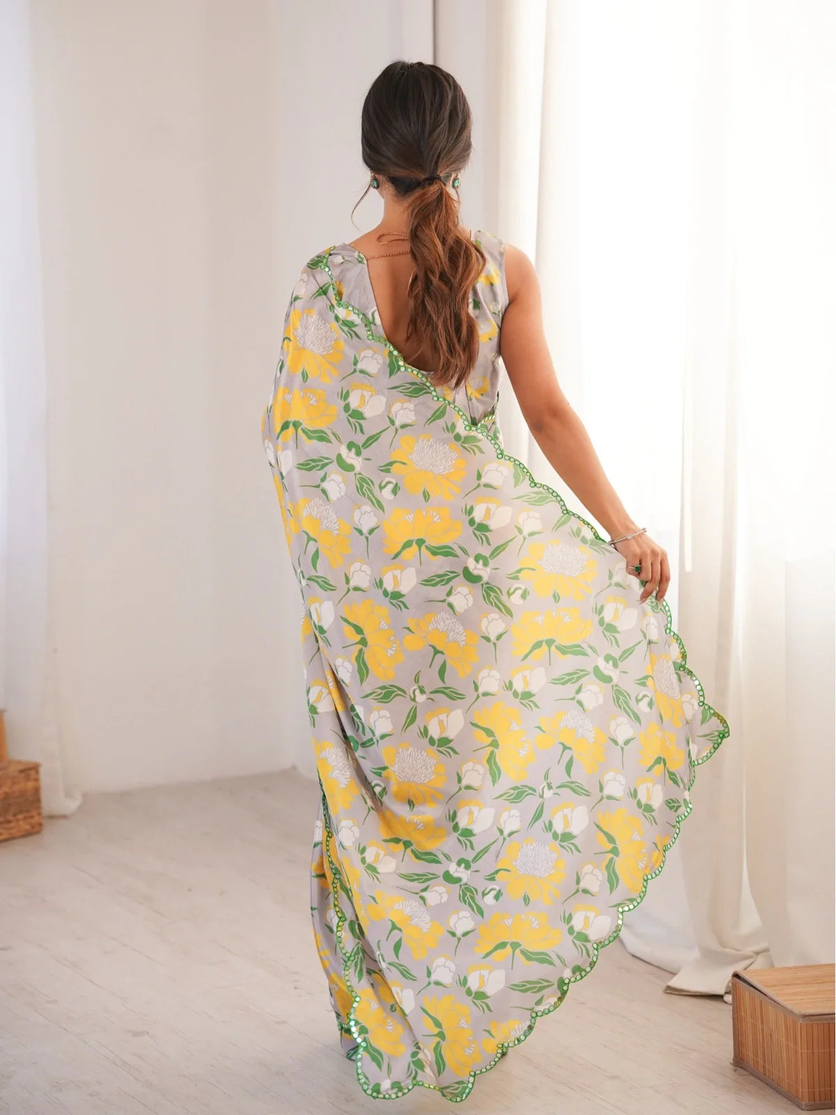 Back view of Tarani floral chinnon saree with draped pallu and deep cut blouse back design