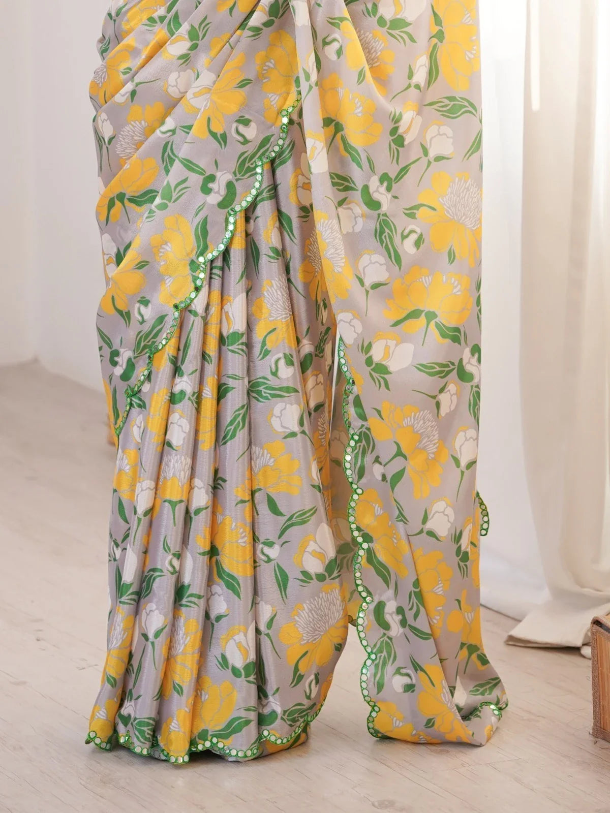 Closeup of Tarani grey chinnon saree showing mirror work scalloped border and floral print detailing