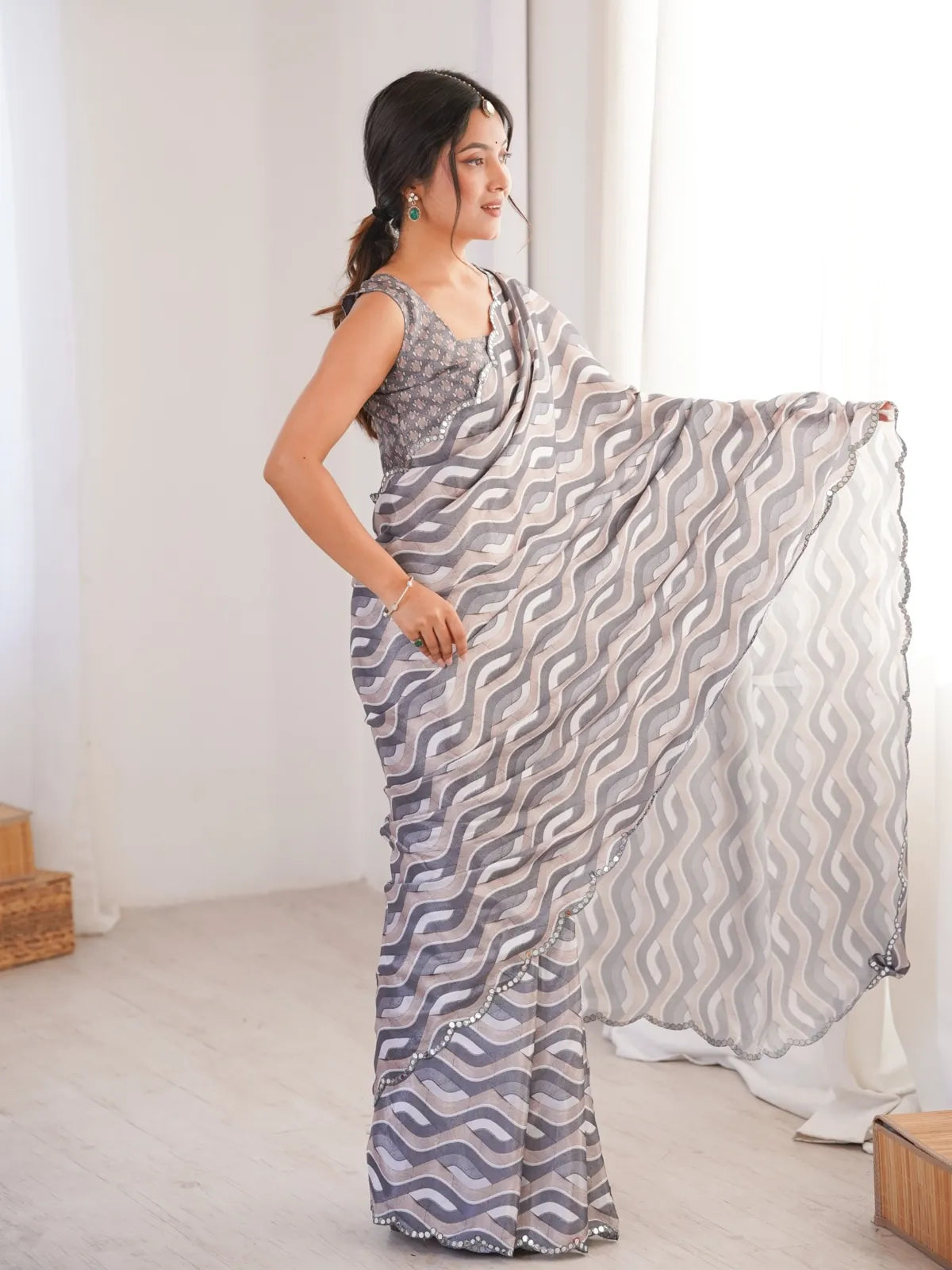 Side pose showing Tarani festive grey saree with flowy pallu and mirror finish