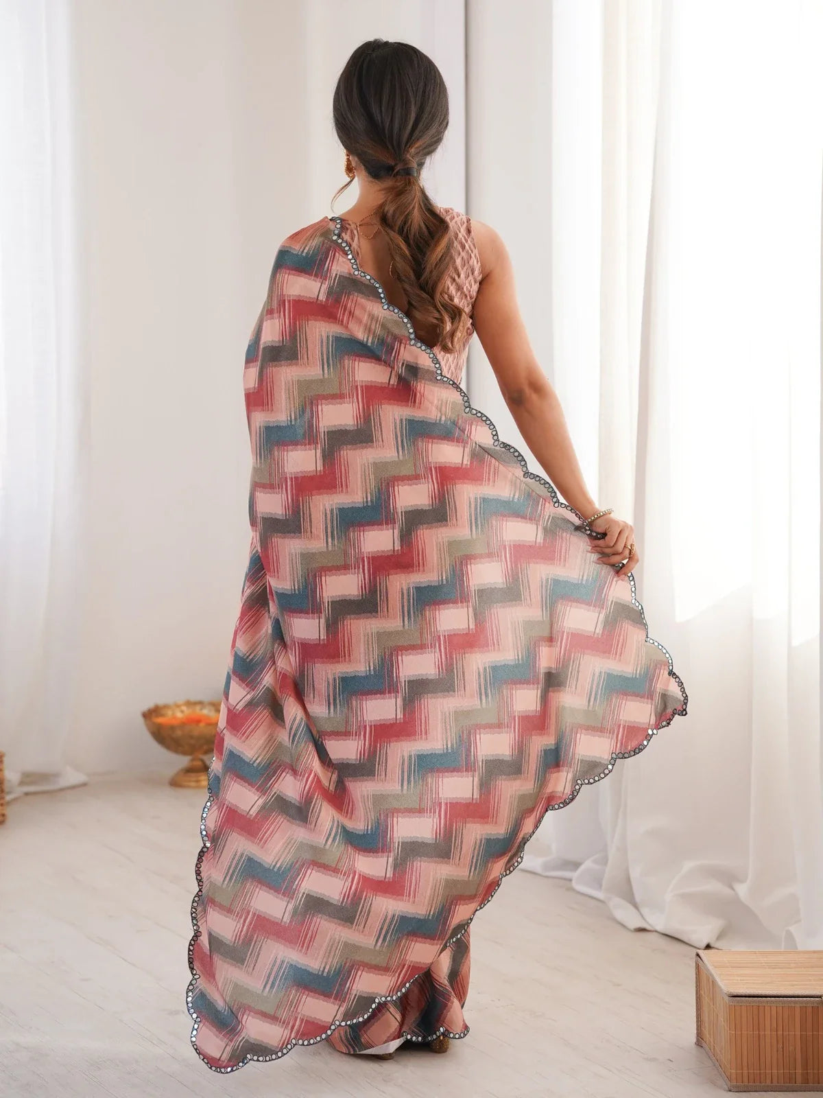 Tarani back view showing flow of multicolor saree and blouse design in chinnon fabric