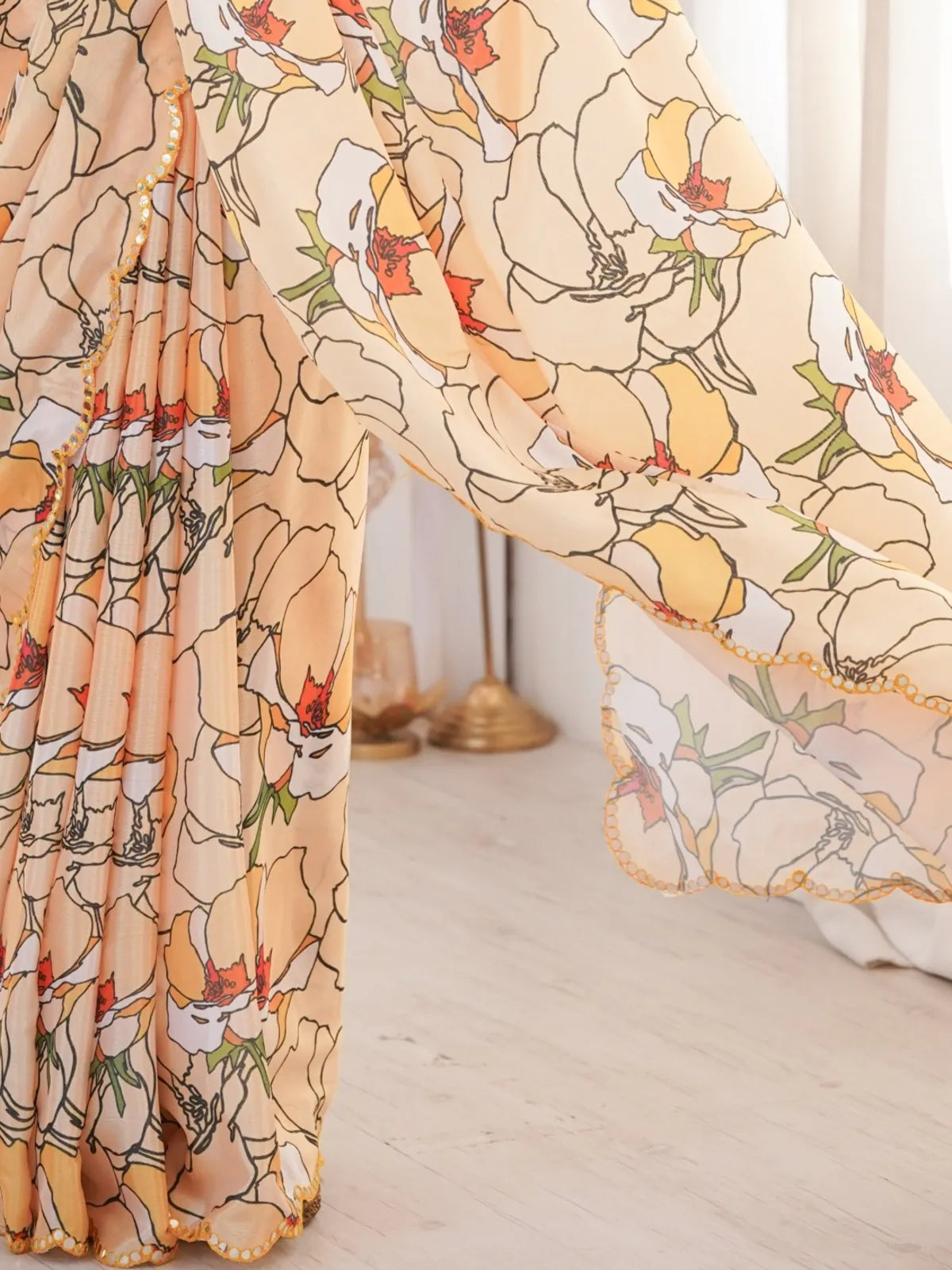 Tarani peach chinnon saree with closeup view showcasing printed floral design and mirror work border