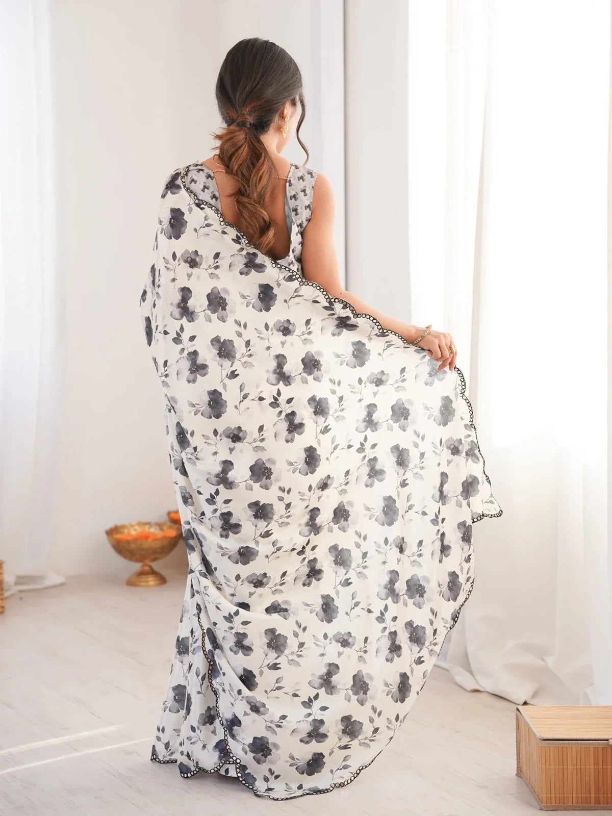 Back view of Tarani white chinnon saree with flowing floral pallu and elegant drape