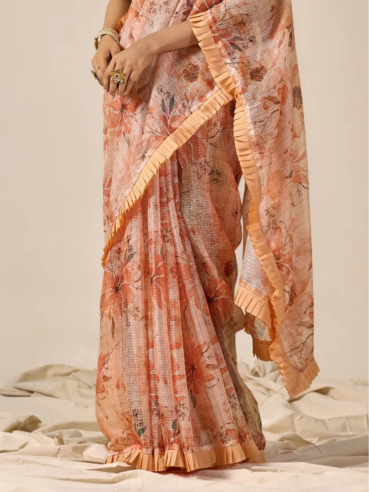 Tarani closeup view of peach floral cotton blend saree showing fine Kota weave and ruffled border