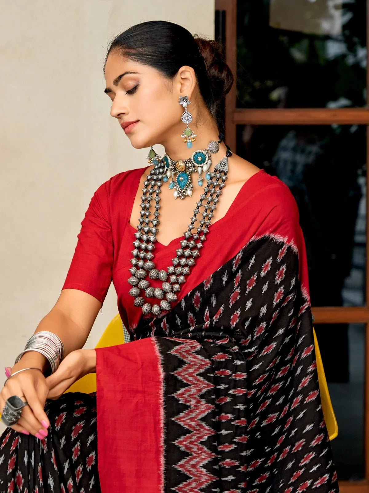 Tarani elegant red and black Ikat cotton saree upper body closeup view with jewellery