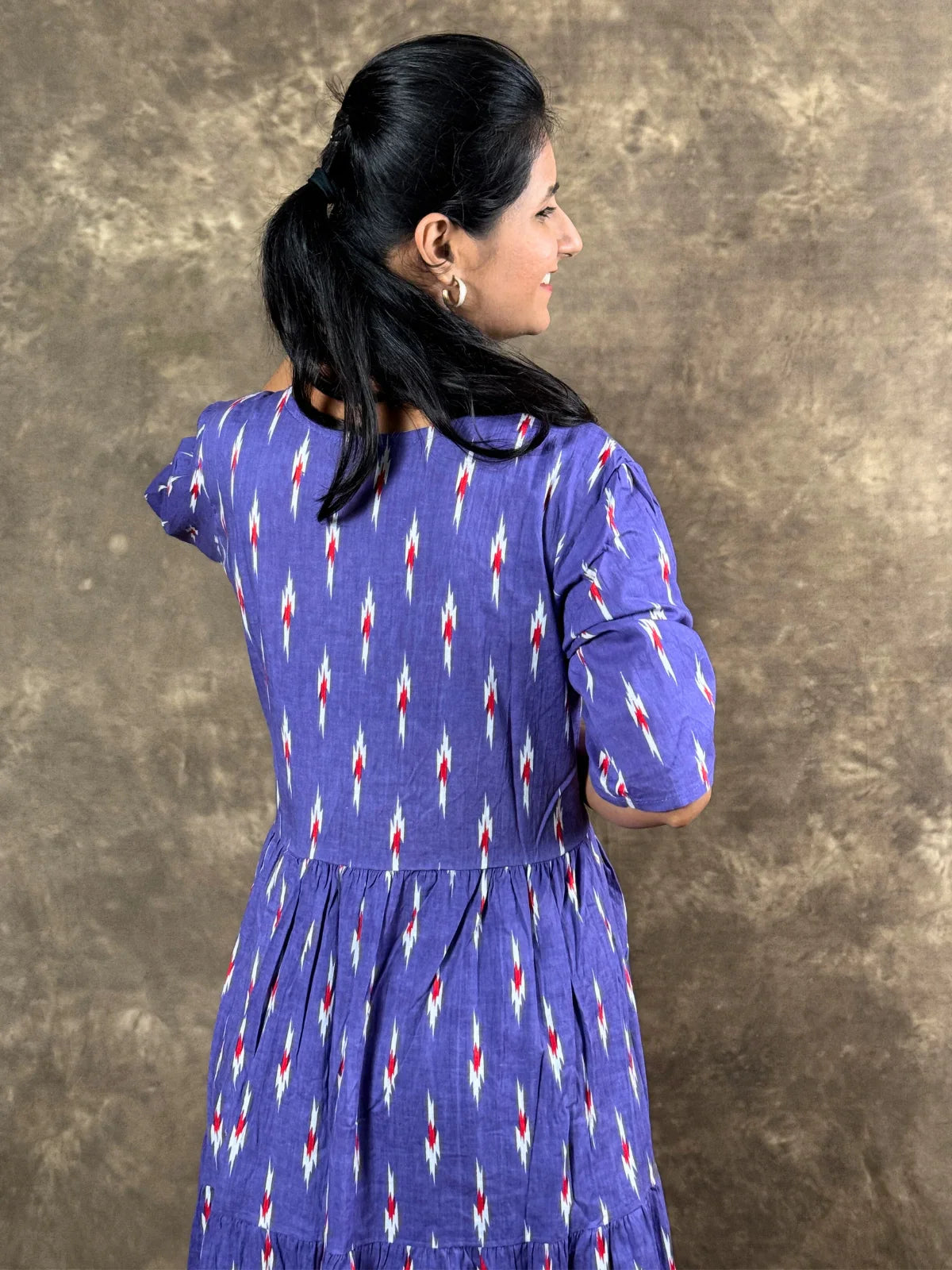 Tarani purple cotton midi dress back view showing flowy tiers and soft drape