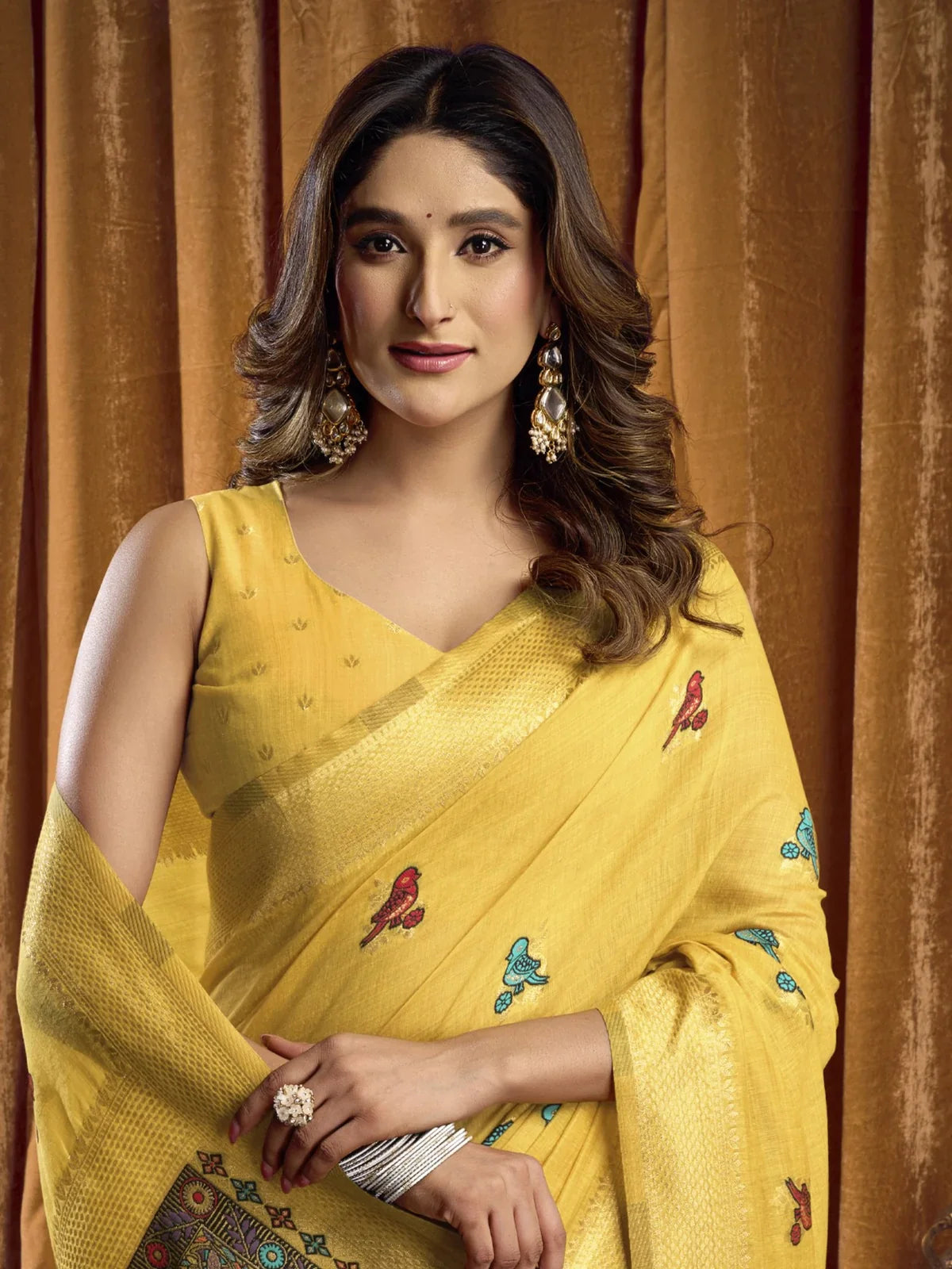 Tarani cotton saree in yellow with sleeveless blouse and earrings upper body view