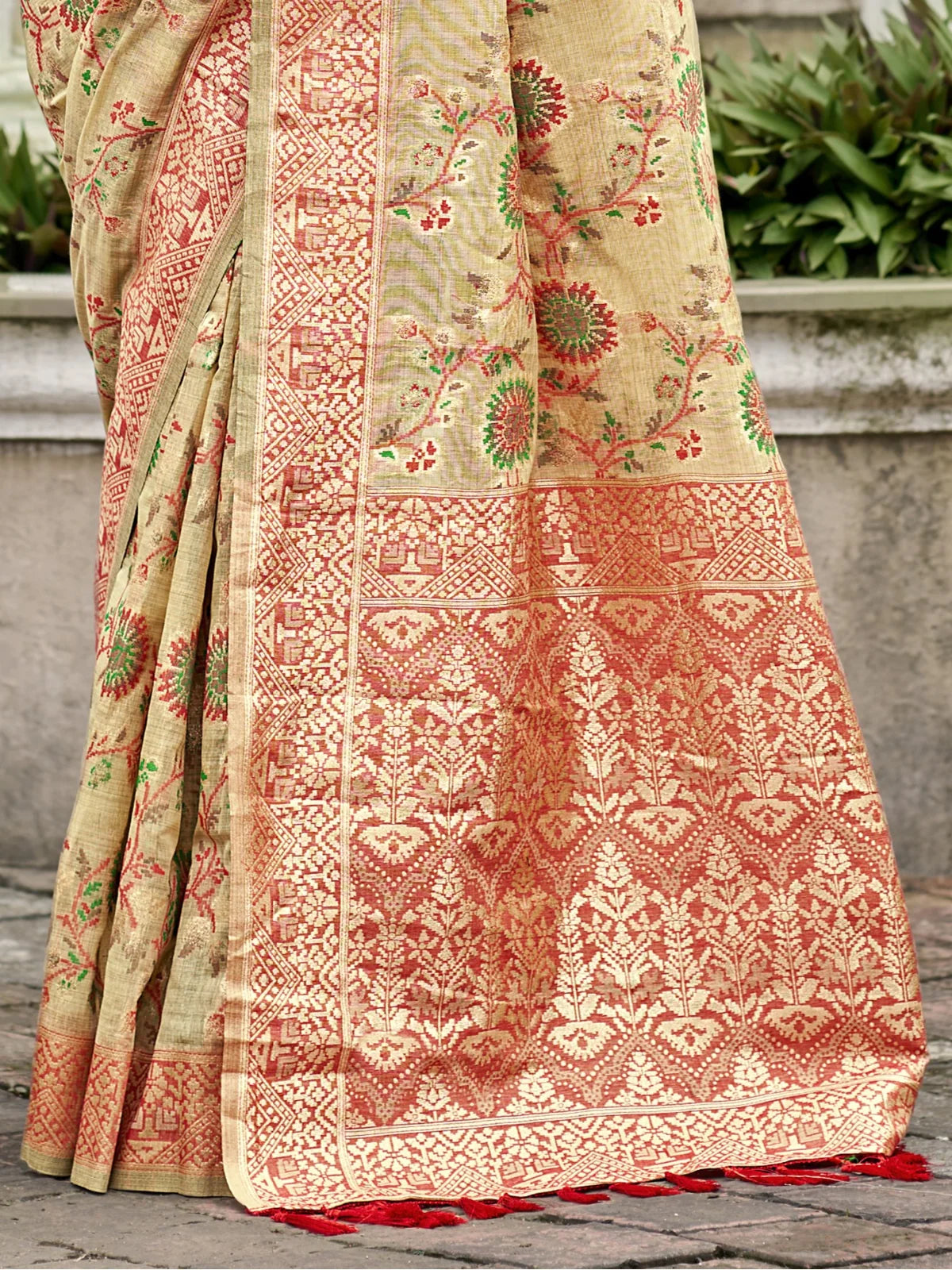 Tarani pallu view showing intricate red woven border with tassels on cotton silk green saree