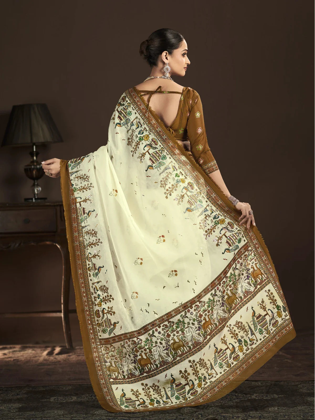 Tarani full back pose showing pallu and rich border design on off white crepe silk saree